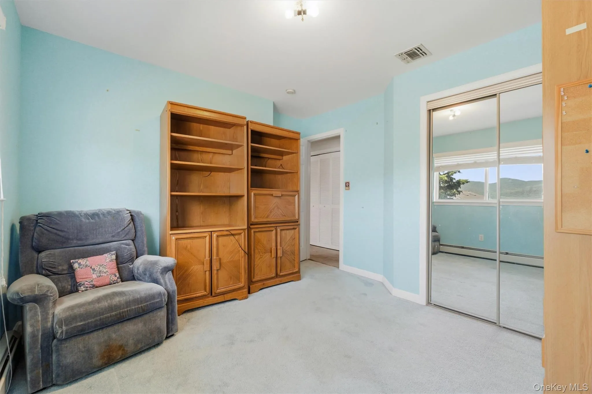 Room featuring light blue walls and blue carpet flooring Room featuring light blue walls and blue carpet flooring