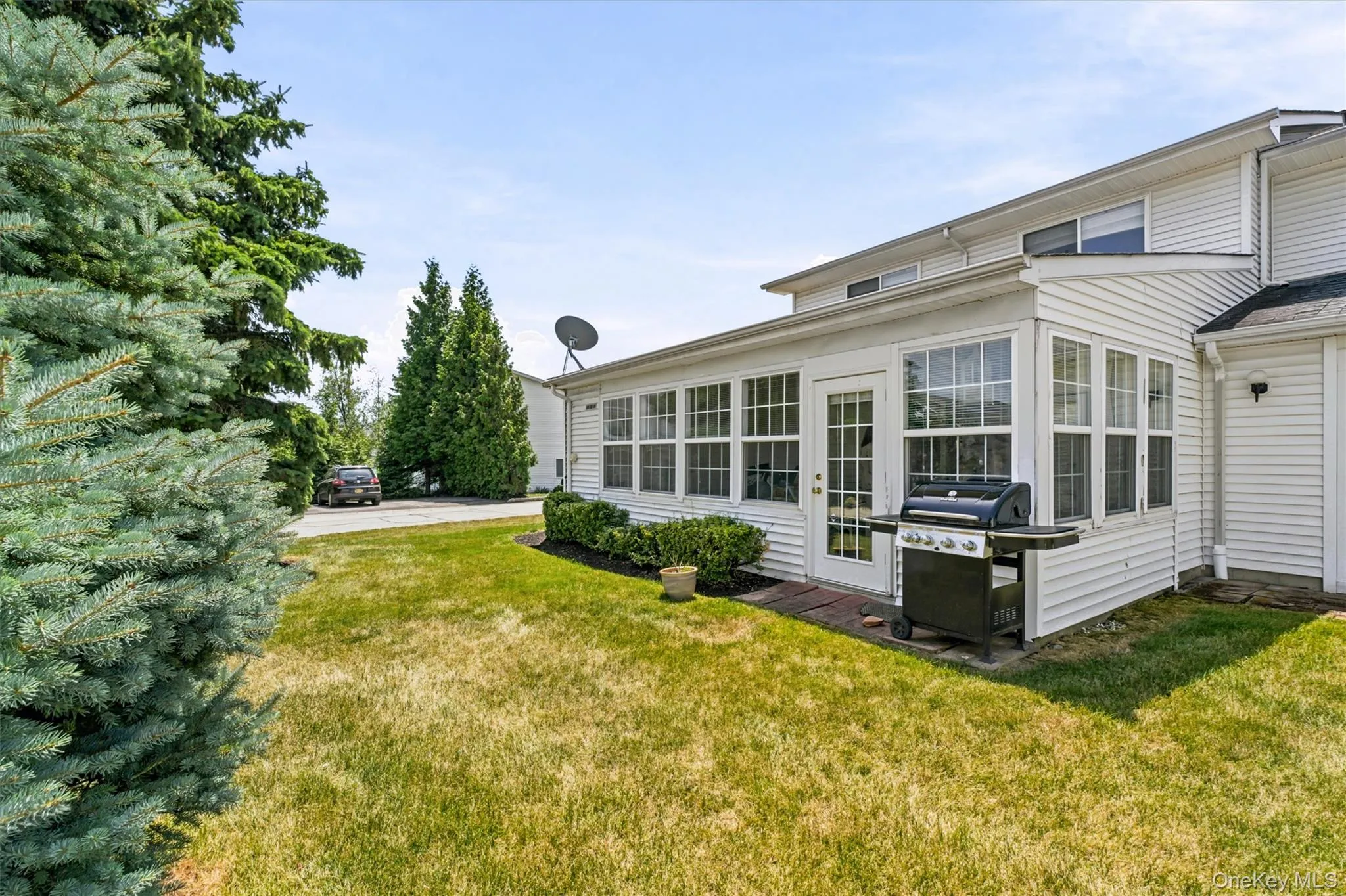 Exterior view showcasing the screened-in porch, private lawn, and well-maintained landscaping, offering additional outdoor space. Exterior view showcasing the screened-in porch, private lawn, and well-maintained landscaping, offering additional outdoor space.