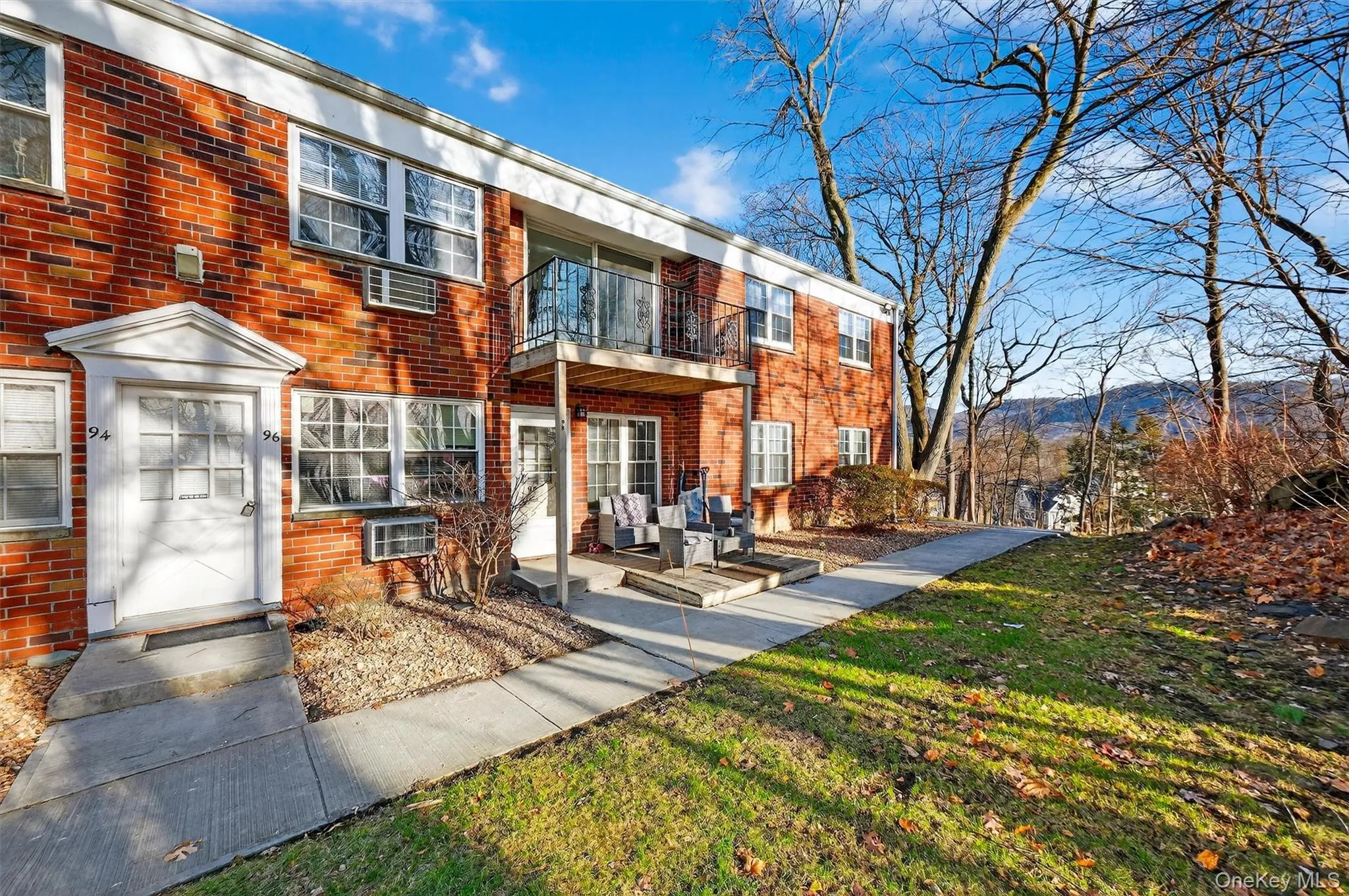 Back of house with a balcony, brick siding, a lawn, and an outdoor living space Back of house with a balcony, brick siding, a lawn, and an outdoor living space