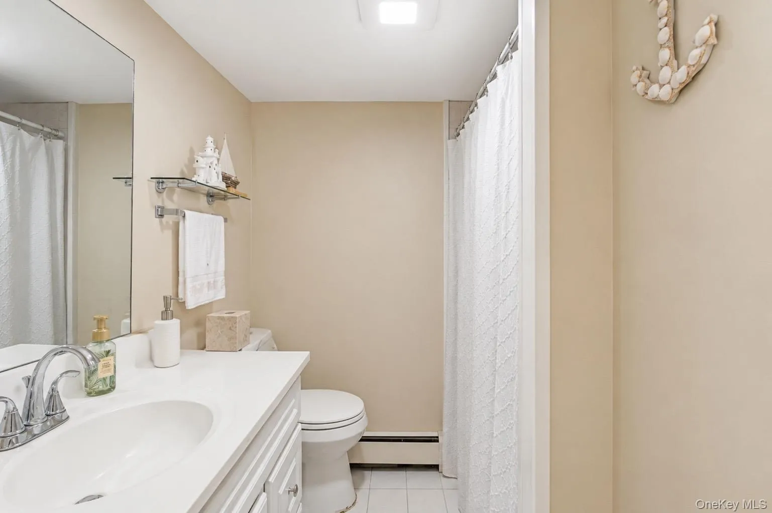 Bathroom featuring a vanity with an integrated sink, chrome faucet, and mirrored wall Bathroom featuring a vanity with an integrated sink, chrome faucet, and mirrored wall