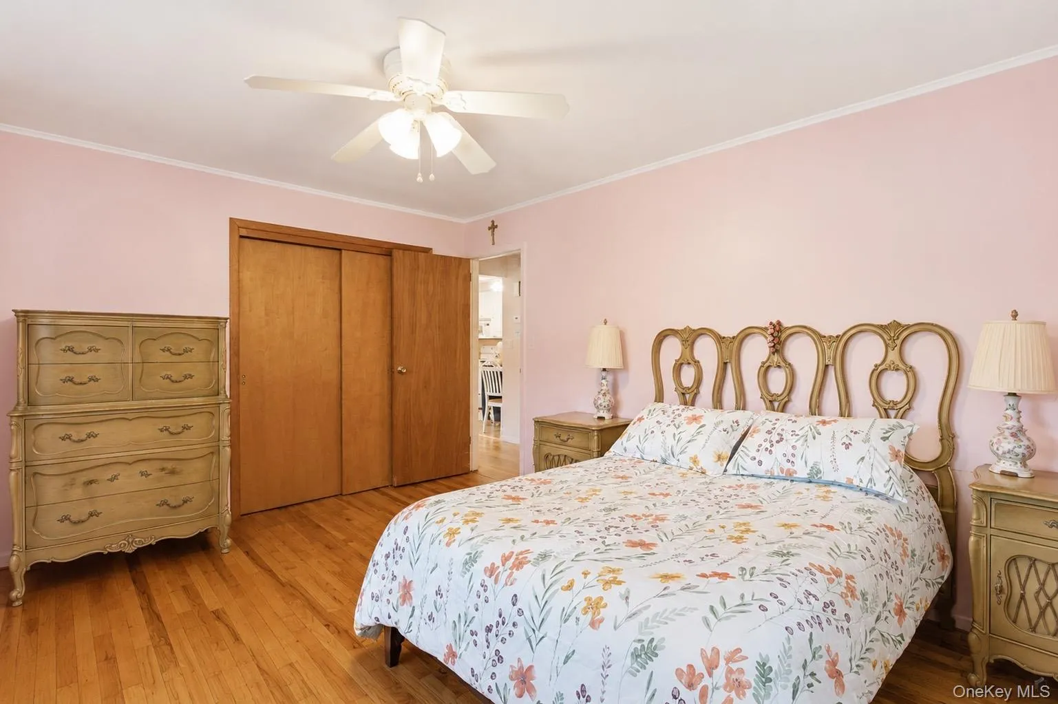 Hardwood flooring extends throughout this room, featuring a ceiling fan, baseboard molding, and crown molding Hardwood flooring extends throughout this room, featuring a ceiling fan, baseboard molding, and crown molding