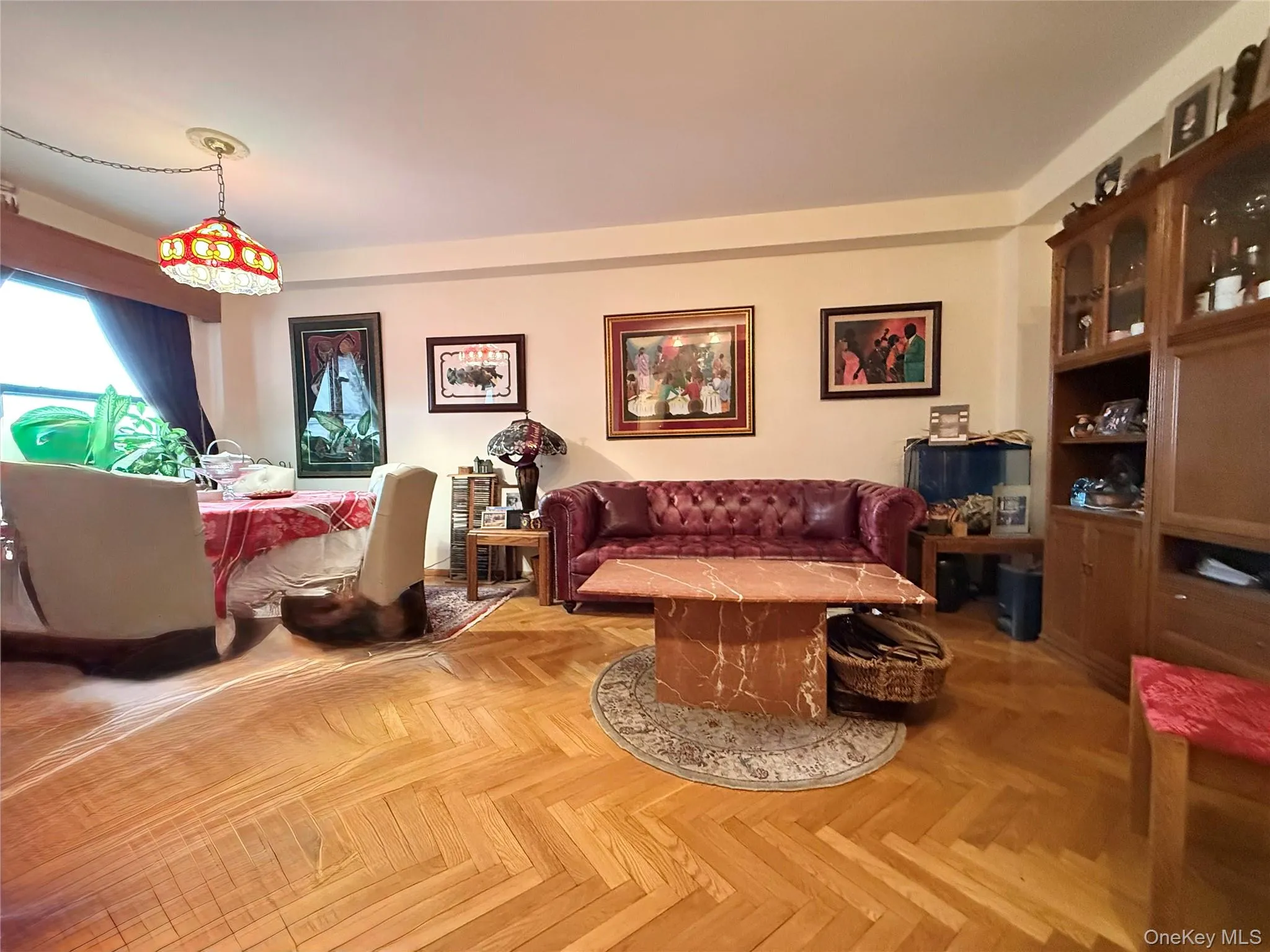 Elegant herringbone hardwood floors, open to the dining area that has a double panel window Elegant herringbone hardwood floors, open to the dining area that has a double panel window