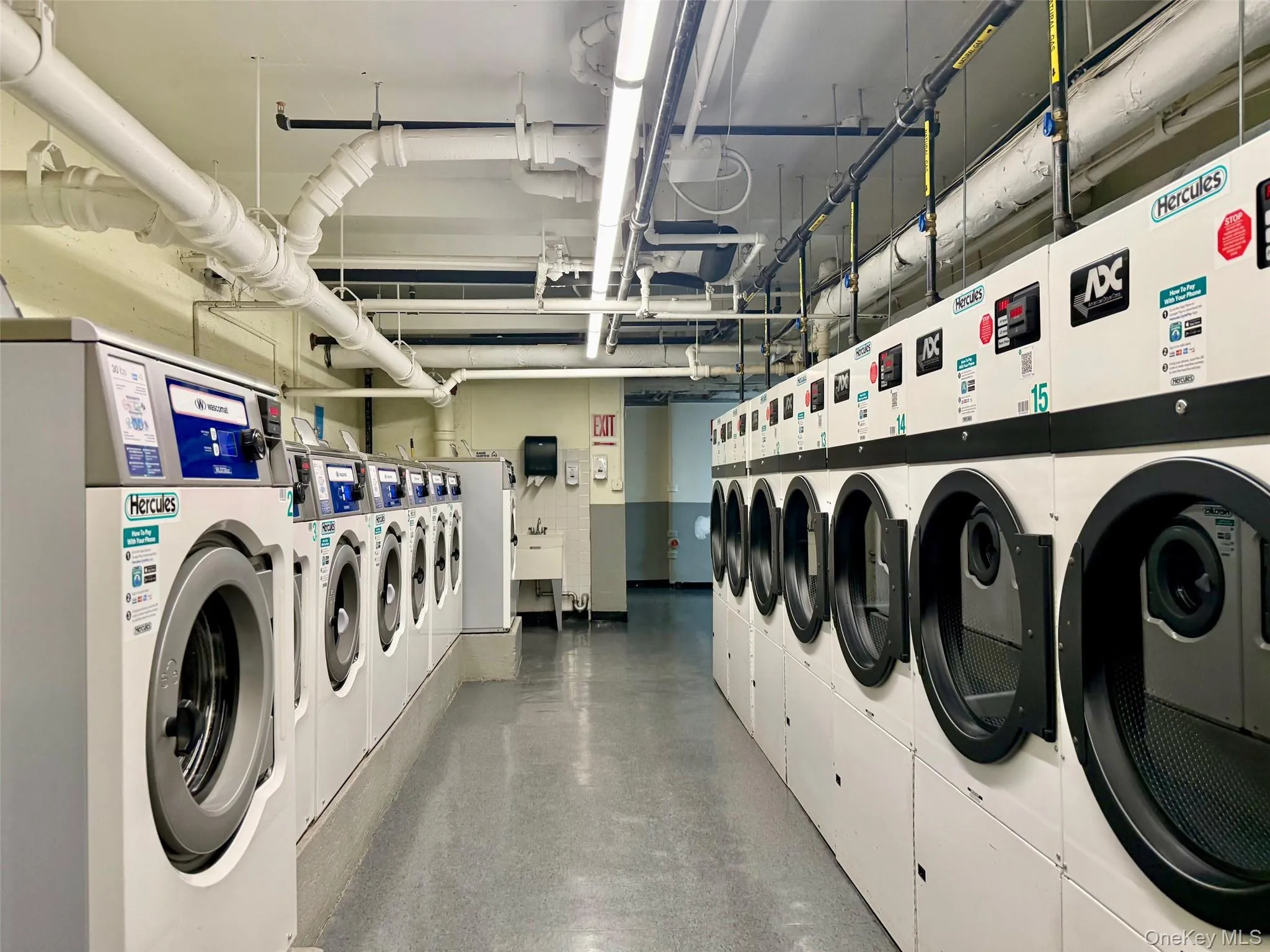 Laundry room Community laundry room featuring multiple front-loading washing machines, durable flooring, and overhead fluorescent lighting Laundry room Community laundry room featuring multiple front-loading washing machines, durable flooring, and overhead fluorescent lighting