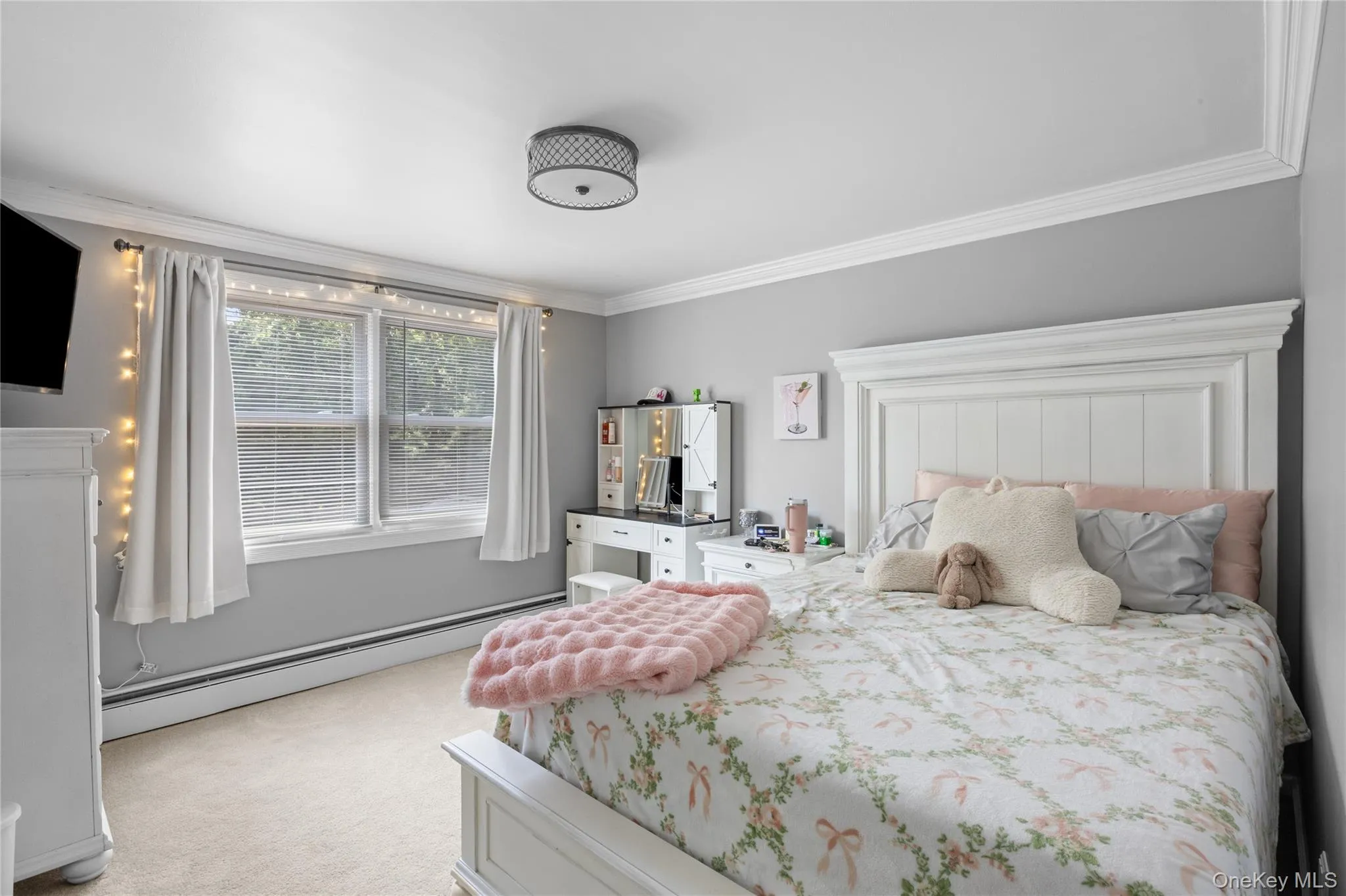 Bedroom featuring ample natural light, crown molding, a decorative ceiling light fixture, and neutral-toned carpeting Bedroom featuring ample natural light, crown molding, a decorative ceiling light fixture, and neutral-toned carpeting