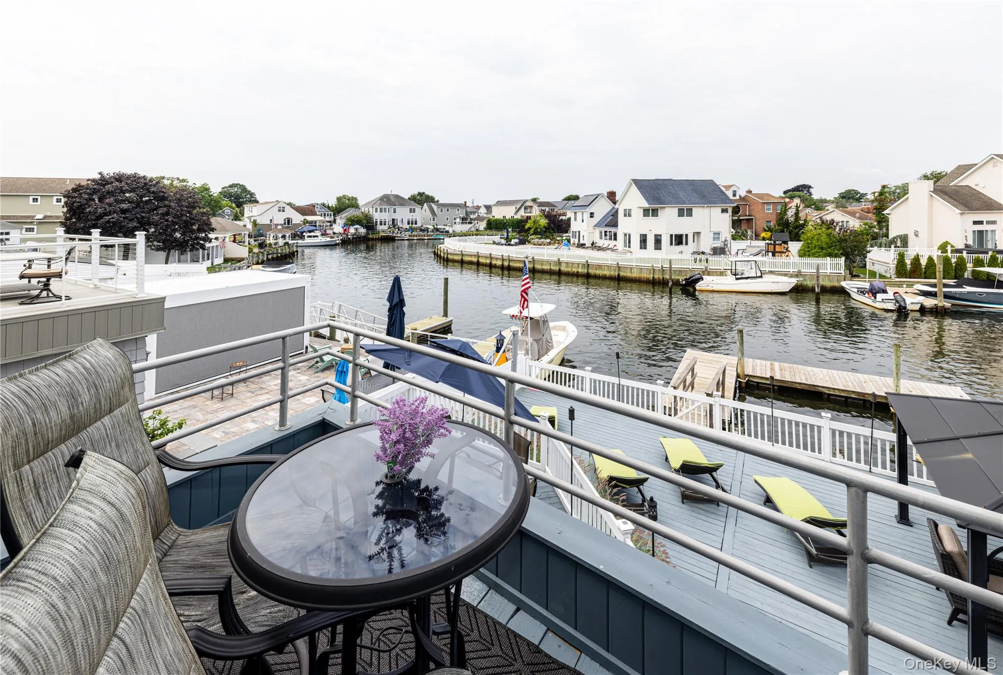 Waterfront deck featuring a gray finish, aluminum railings, and direct water access with multiple docks Waterfront deck featuring a gray finish, aluminum railings, and direct water access with multiple docks