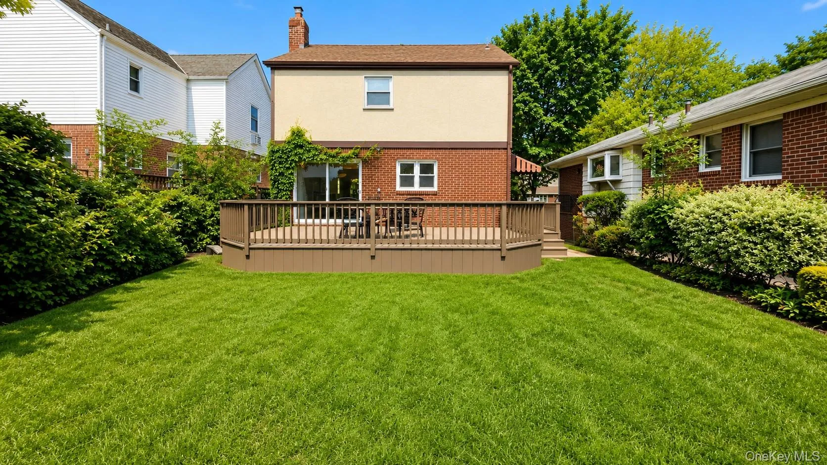 Beautifully manicured backyard with a deck Beautifully manicured backyard with a deck