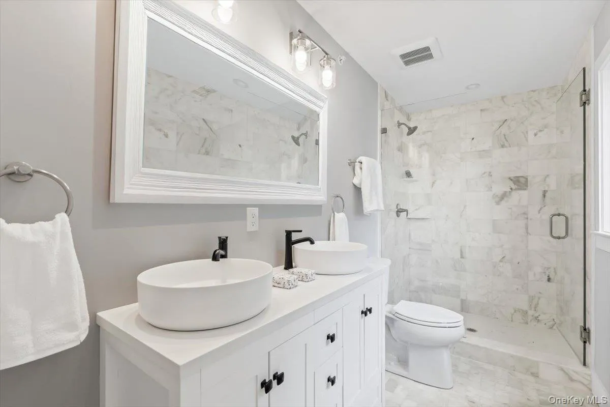 Spa-inspired primary bathroom featuring a custom floating vanity and premium tilework Spa-inspired primary bathroom featuring a custom floating vanity and premium tilework