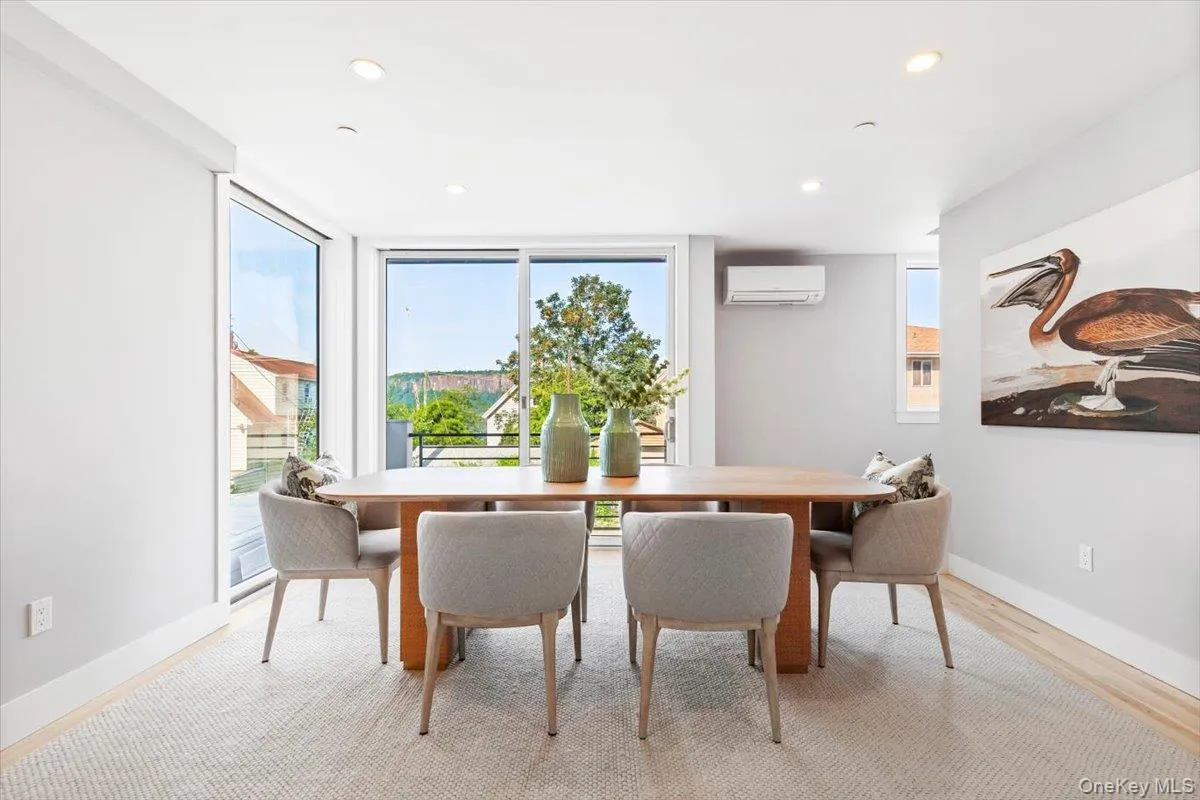 Elegant dining space flanked by expansive windows and sliding doors. Elegant dining space flanked by expansive windows and sliding doors.