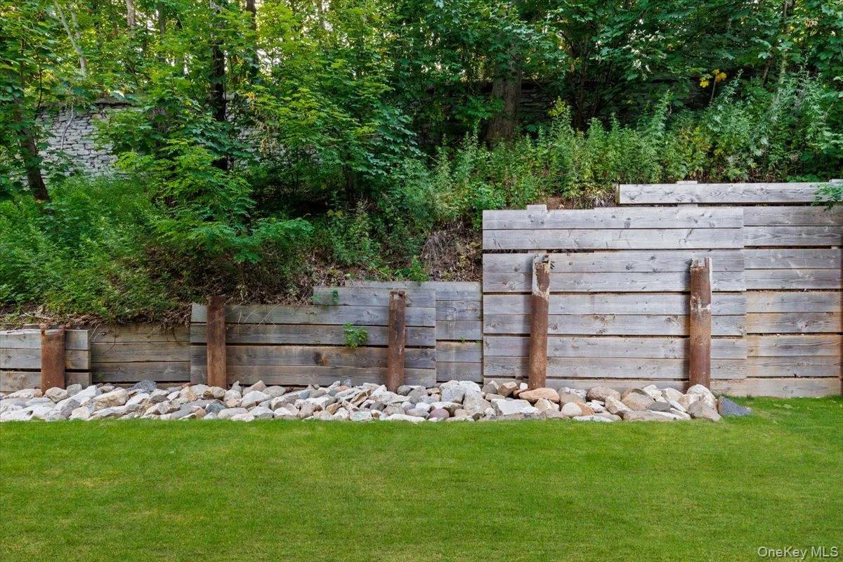 Low-maintenance, private backyard space featuring premium turf and modern retaining walls. Low-maintenance, private backyard space featuring premium turf and modern retaining walls.