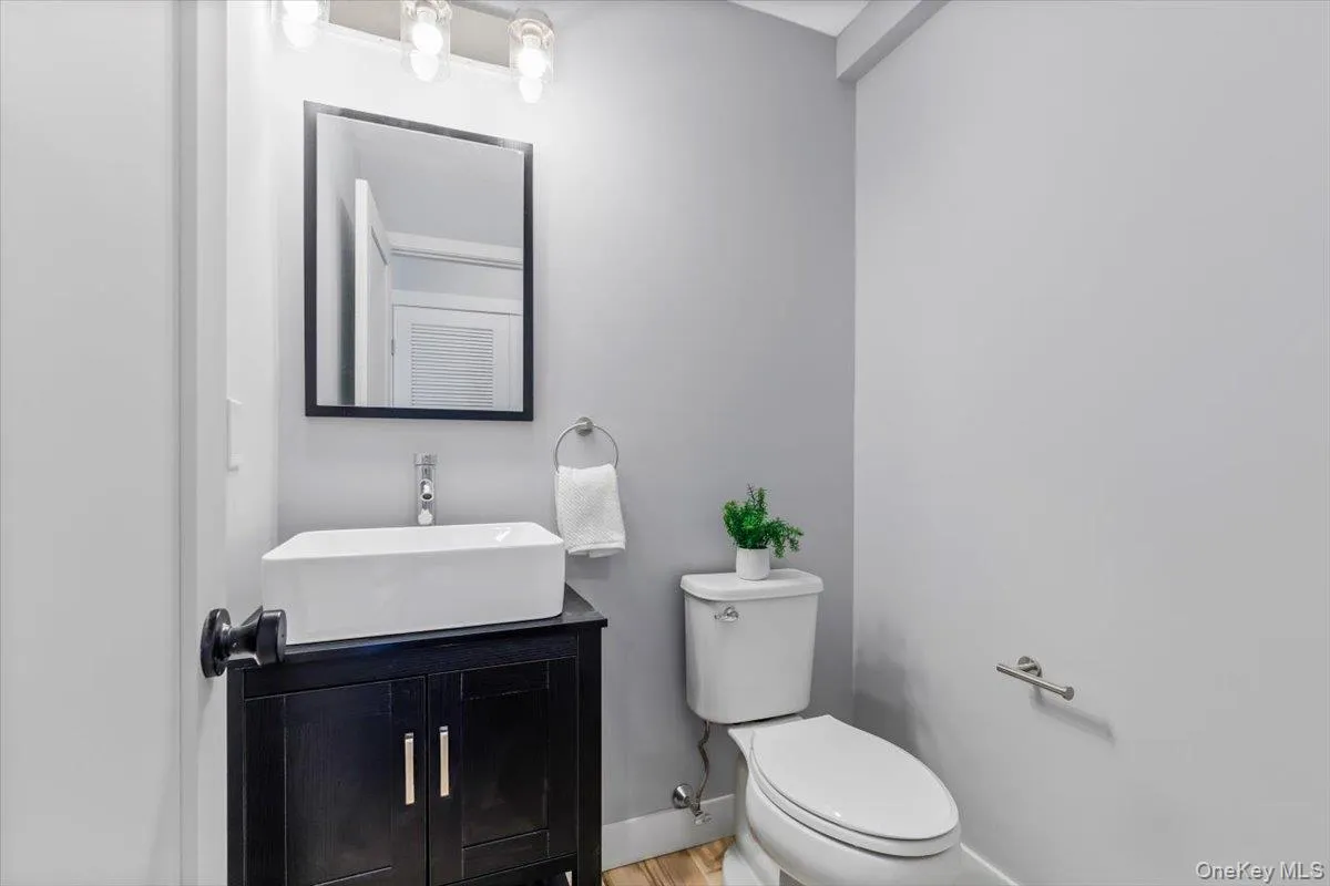 Chic and minimalist main-level powder room for guests. Chic and minimalist main-level powder room for guests.