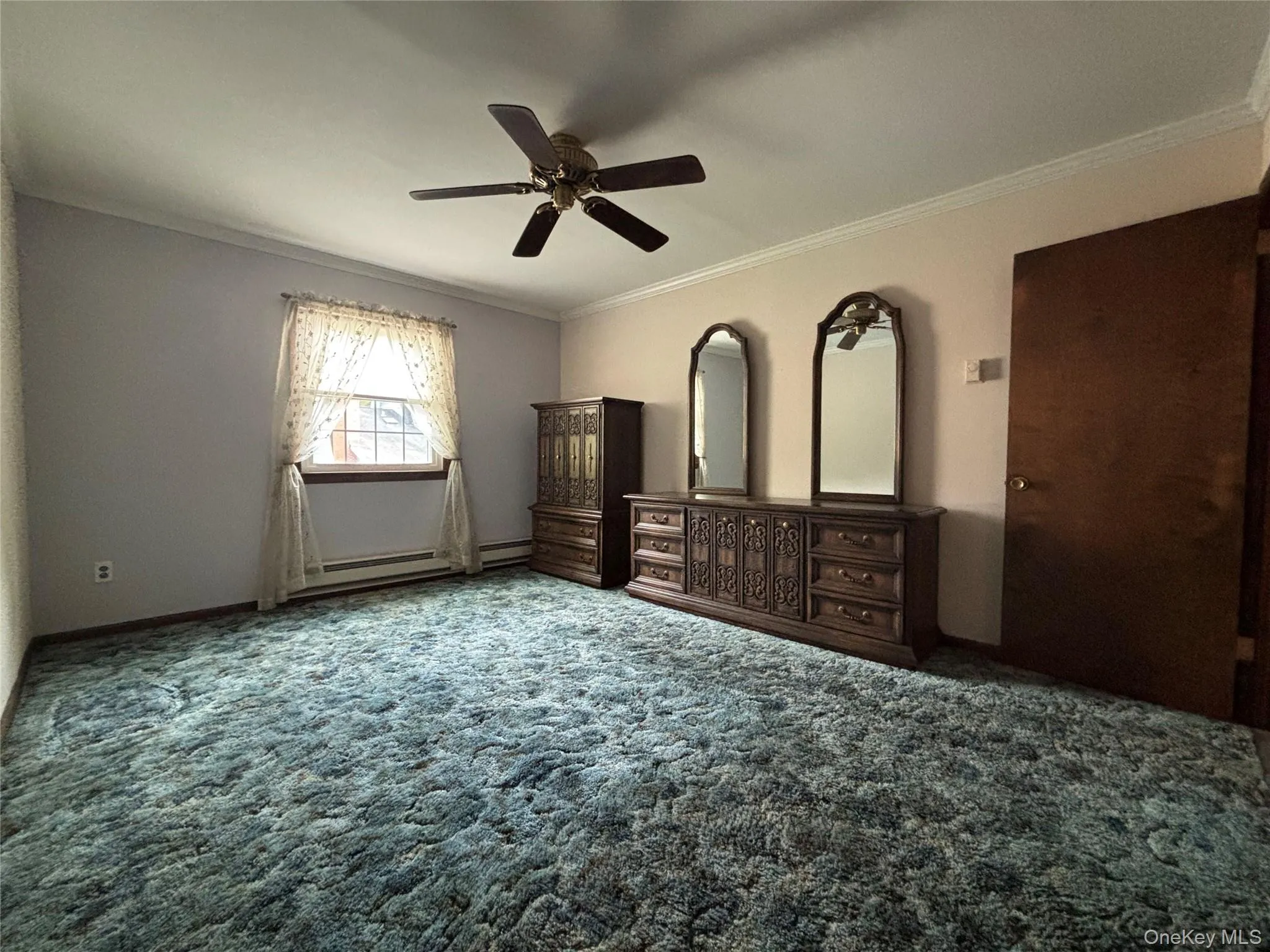 Spacious room featuring wall-to-wall carpeting and a ceiling fan Spacious room featuring wall-to-wall carpeting and a ceiling fan