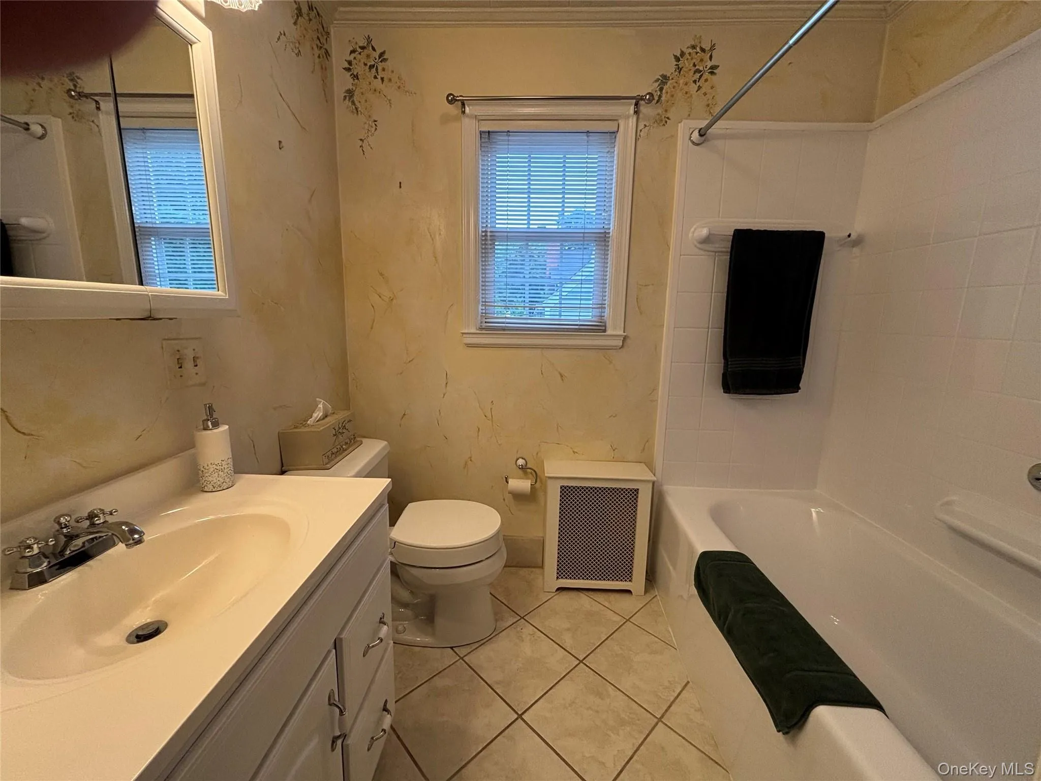 Bathroom featuring a white vanity with integrated sink, chrome faucet, and storage cabinetry Bathroom featuring a white vanity with integrated sink, chrome faucet, and storage cabinetry