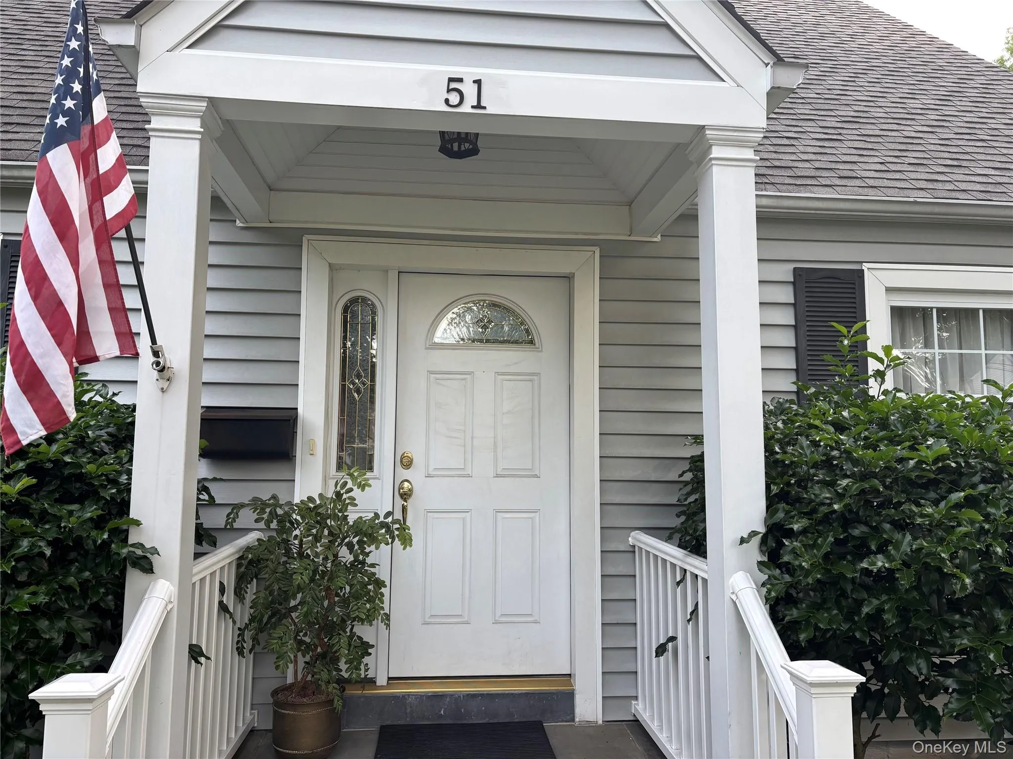 Front entry with light gray siding, white trim, and a covered porch Front entry with light gray siding, white trim, and a covered porch