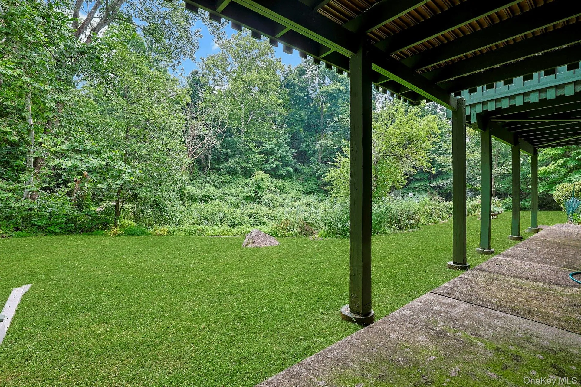 This view of the rear yard is from the lower level sliding glass doors, showing how naturally beautiful the area is. This view of the rear yard is from the lower level sliding glass doors, showing how naturally beautiful the area is.