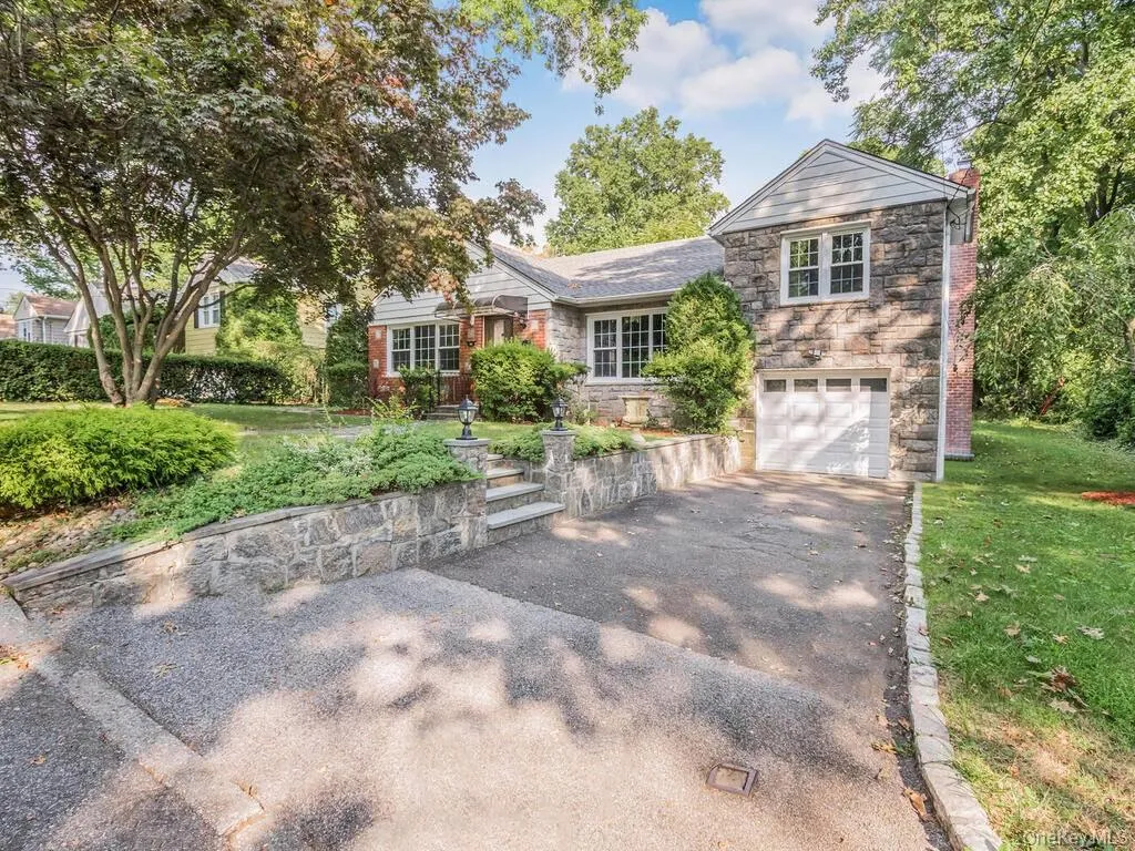 Stone-clad exterior featuring a single-car garage with white door Stone-clad exterior featuring a single-car garage with white door