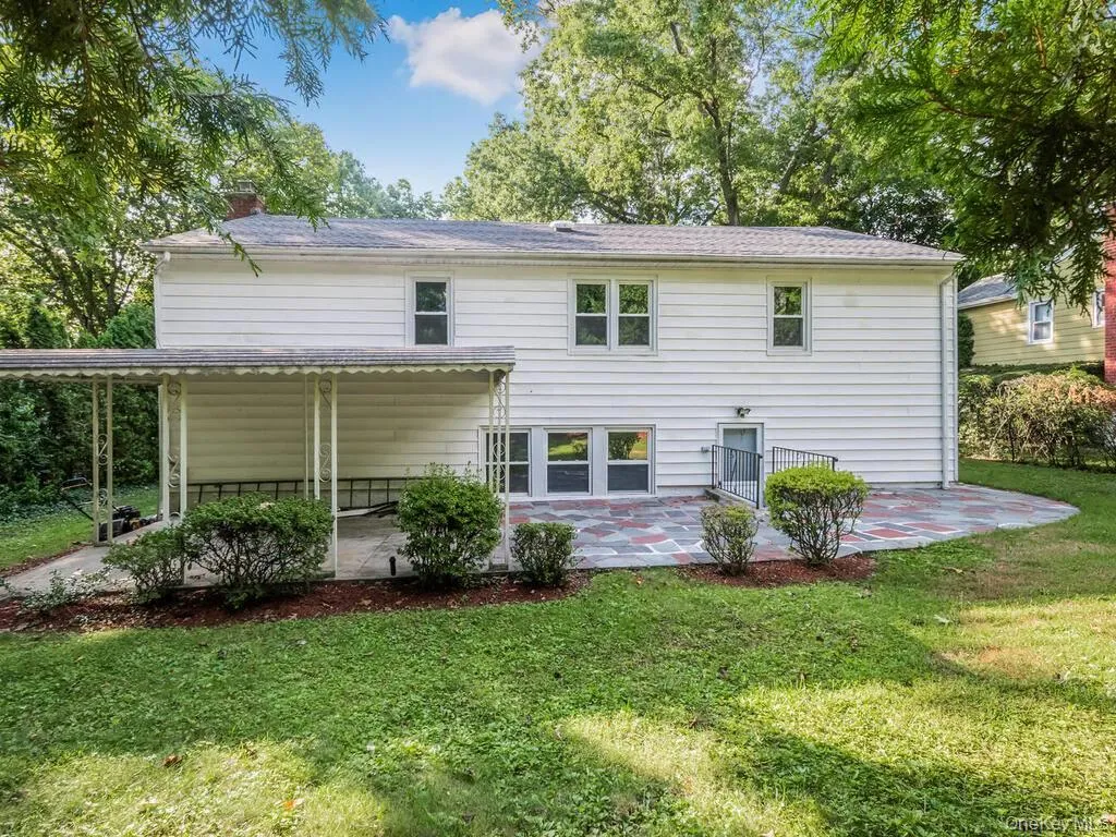 Rear exterior featuring white horizontal siding and a gray shingled roof Rear exterior featuring white horizontal siding and a gray shingled roof