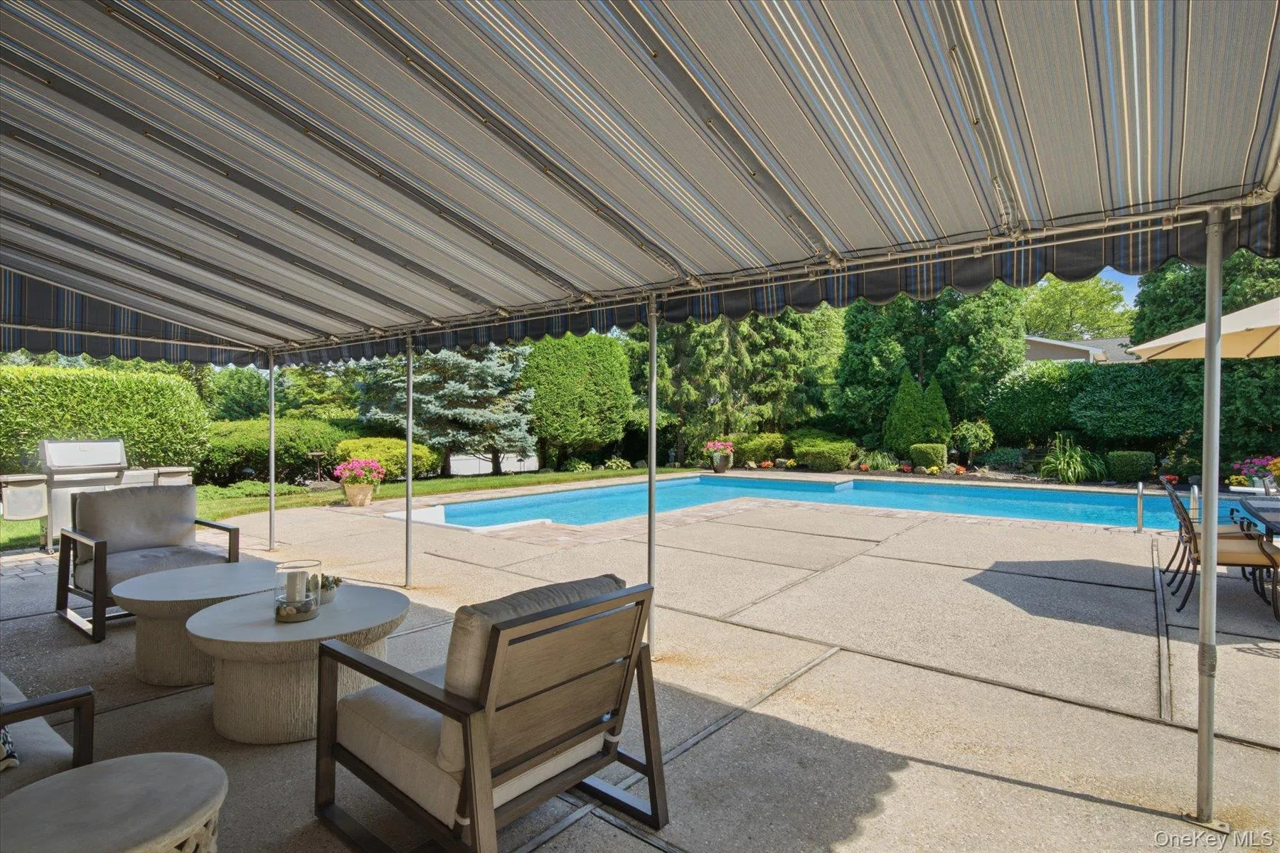 Spacious patio with covered awning offers relaxing views of the pool Spacious patio with covered awning offers relaxing views of the pool