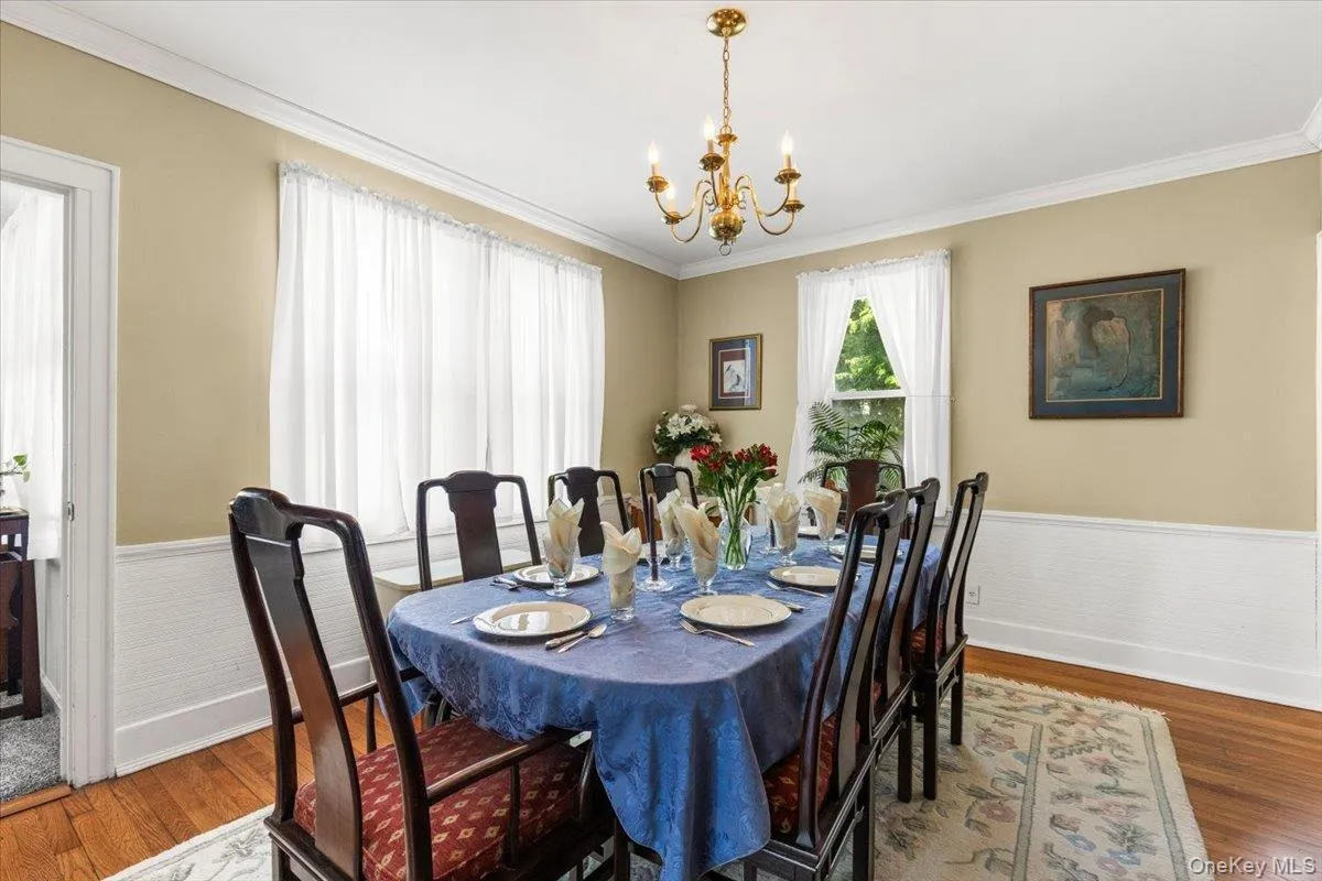 Formal dining space featuring wood-finish flooring, white wainscoting, and crown molding Formal dining space featuring wood-finish flooring, white wainscoting, and crown molding