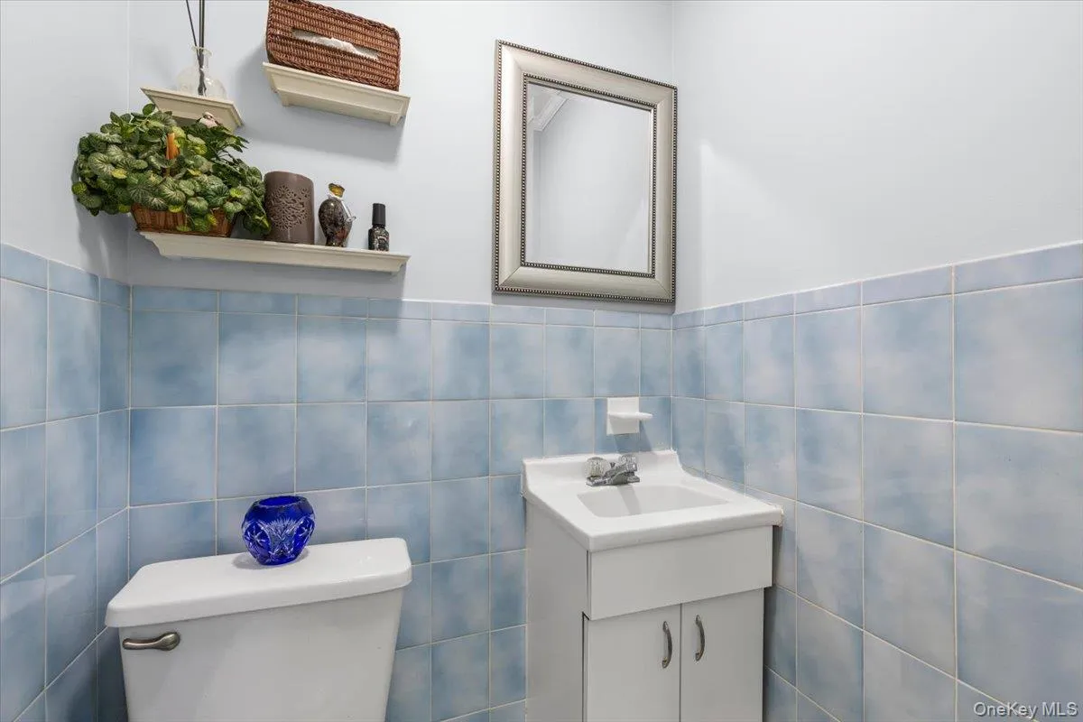 Bathroom featuring light blue wall tiles and white painted walls Bathroom featuring light blue wall tiles and white painted walls