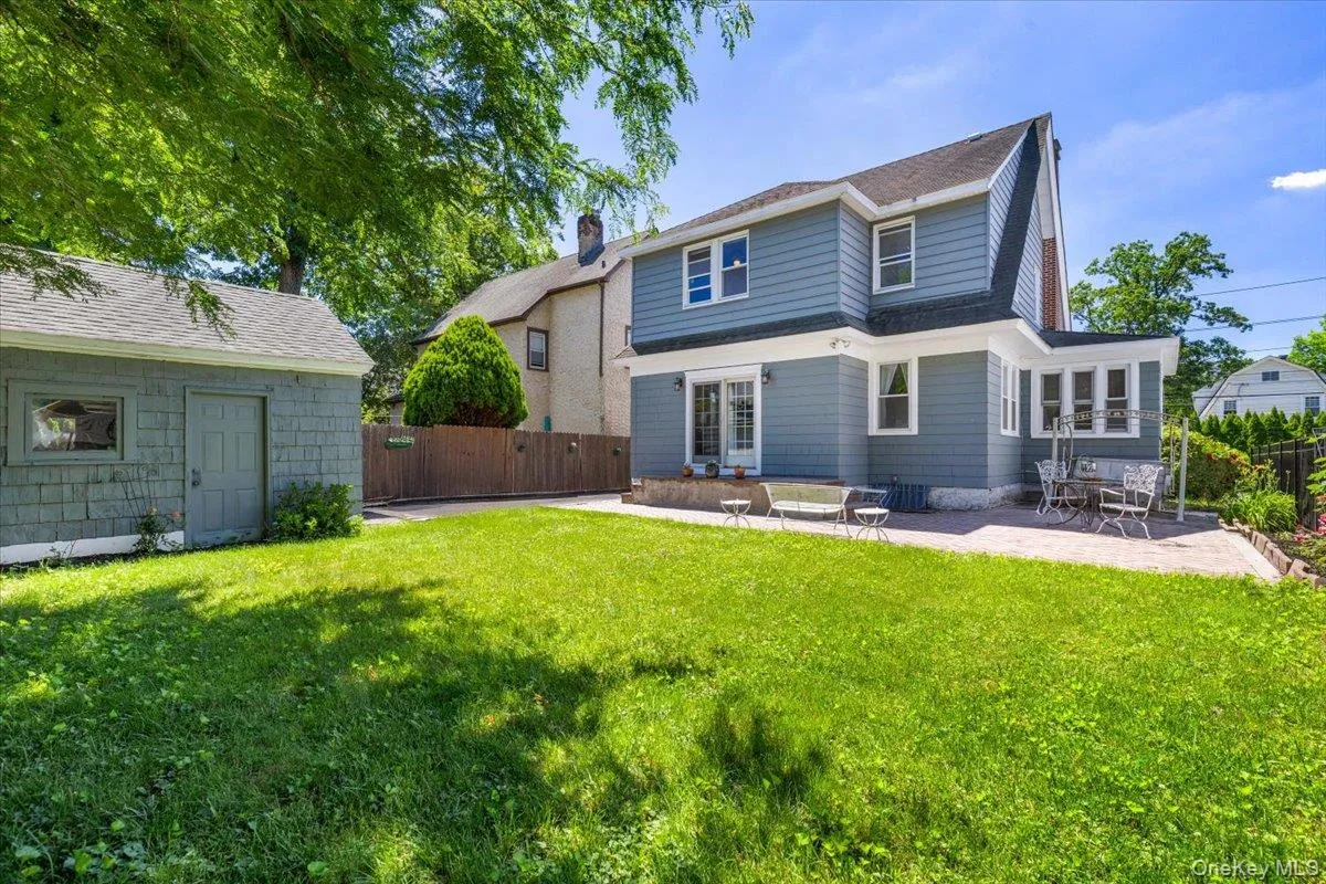 Expansive green lawn with a detached storage shed featuring shingle siding Expansive green lawn with a detached storage shed featuring shingle siding