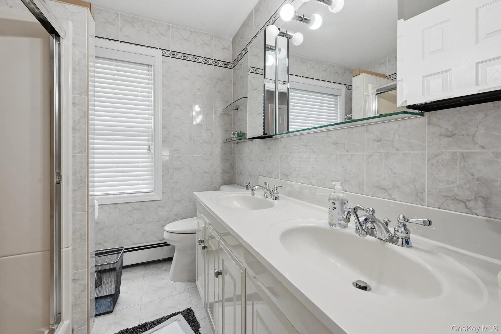 Dual vanity with integrated sinks and chrome fixtures on the second floor Dual vanity with integrated sinks and chrome fixtures on the second floor
