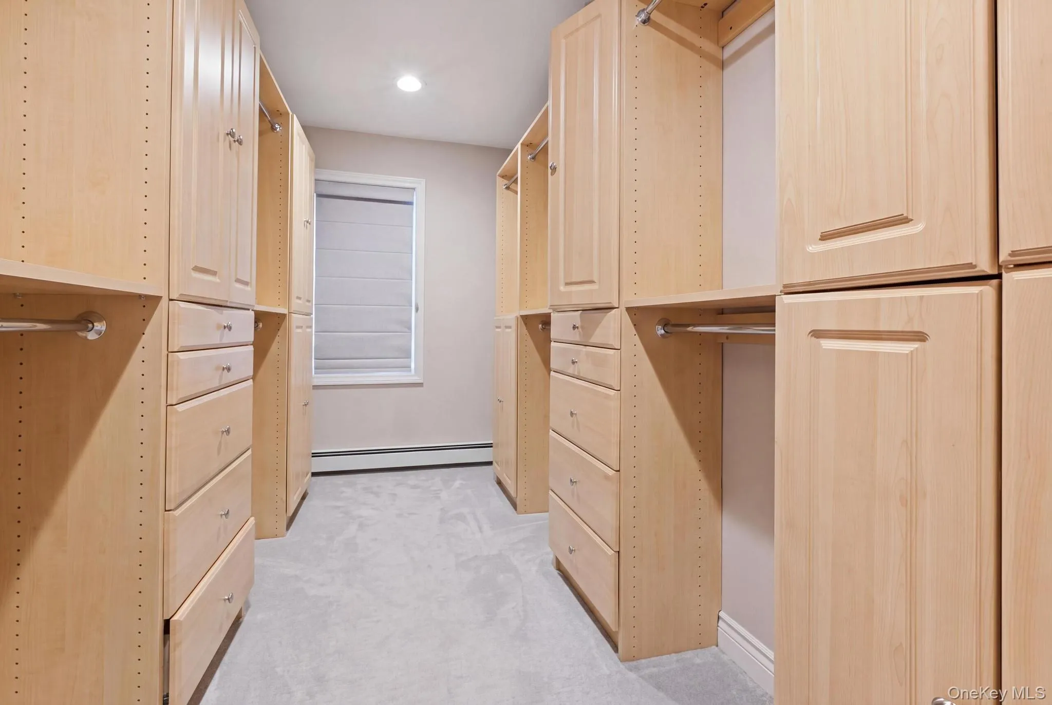 Custom closet system featuring light wood cabinetry Custom closet system featuring light wood cabinetry
