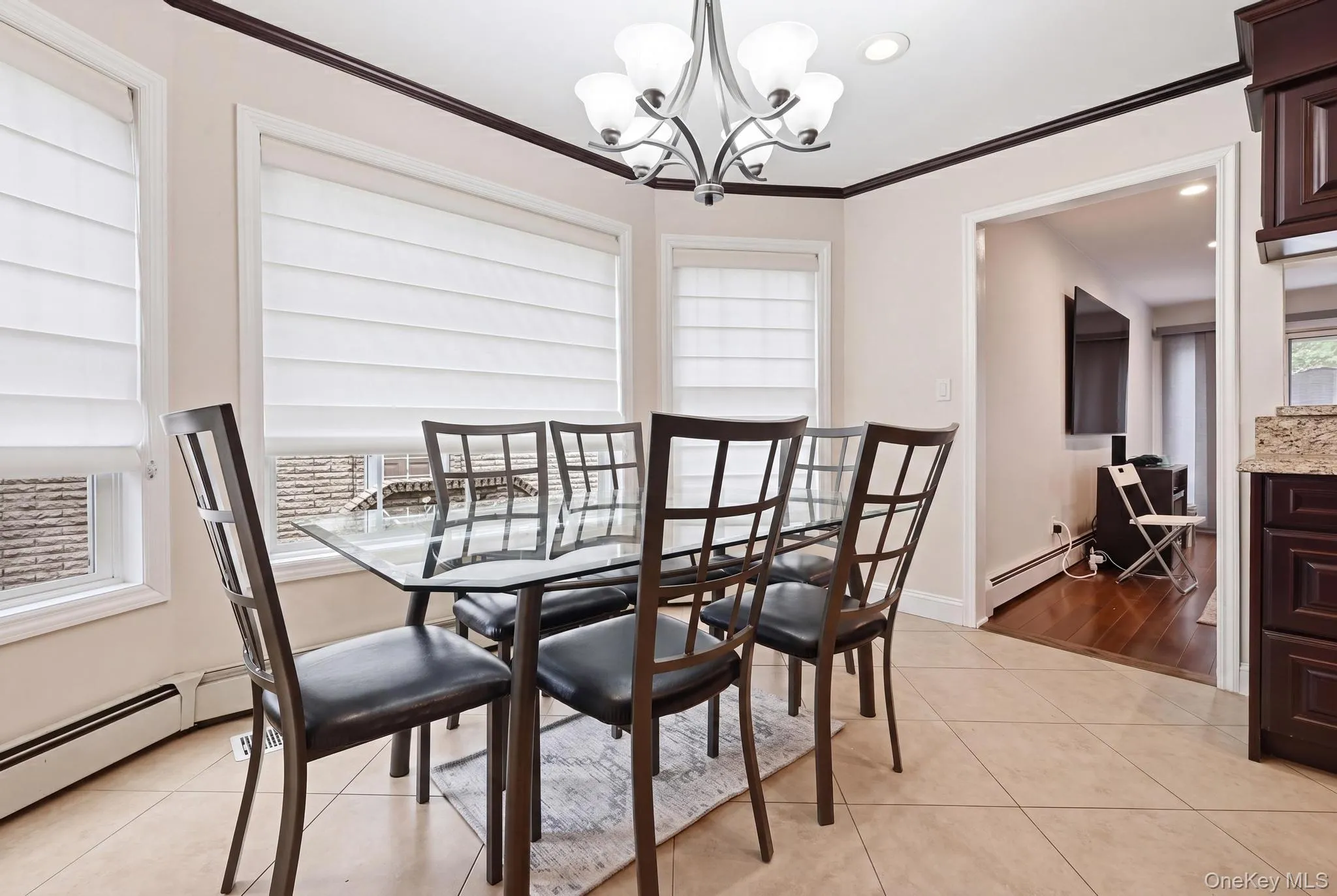 Breakfast nook featuring three windows with white window treatments, a chandelier and recessed lighting Breakfast nook featuring three windows with white window treatments, a chandelier and recessed lighting