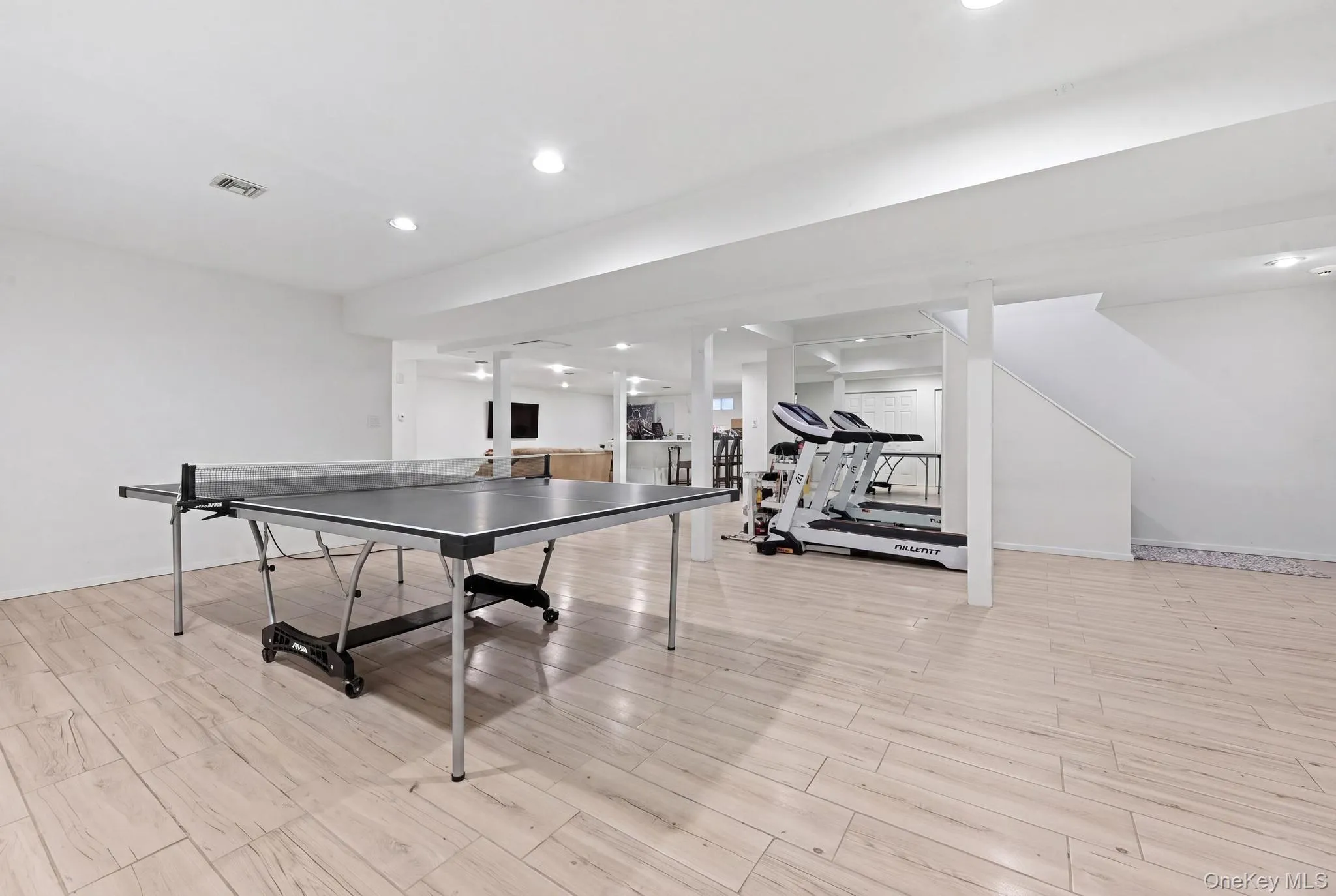 Spacious lower level featuring wood-finish flooring, recessed lighting, and white painted walls Spacious lower level featuring wood-finish flooring, recessed lighting, and white painted walls