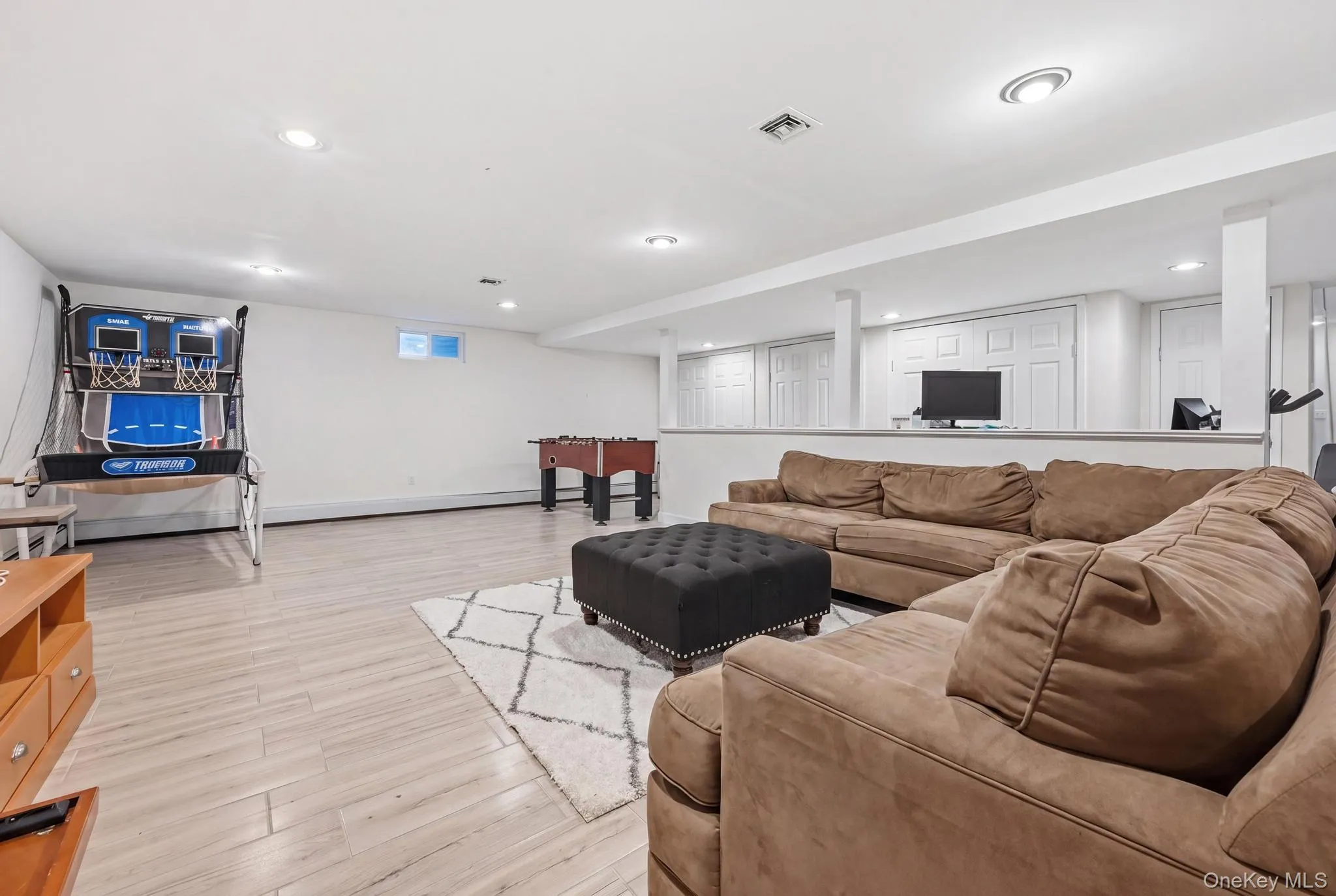 Finished lower level featuring recessed lighting, light wood-finish flooring, and crisp white walls Finished lower level featuring recessed lighting, light wood-finish flooring, and crisp white walls