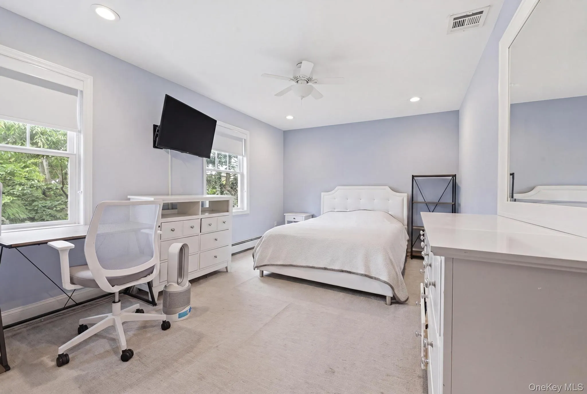 Light-filled room featuring two windows with white trim, recessed lighting, a ceiling fan, and carpeted flooring Light-filled room featuring two windows with white trim, recessed lighting, a ceiling fan, and carpeted flooring