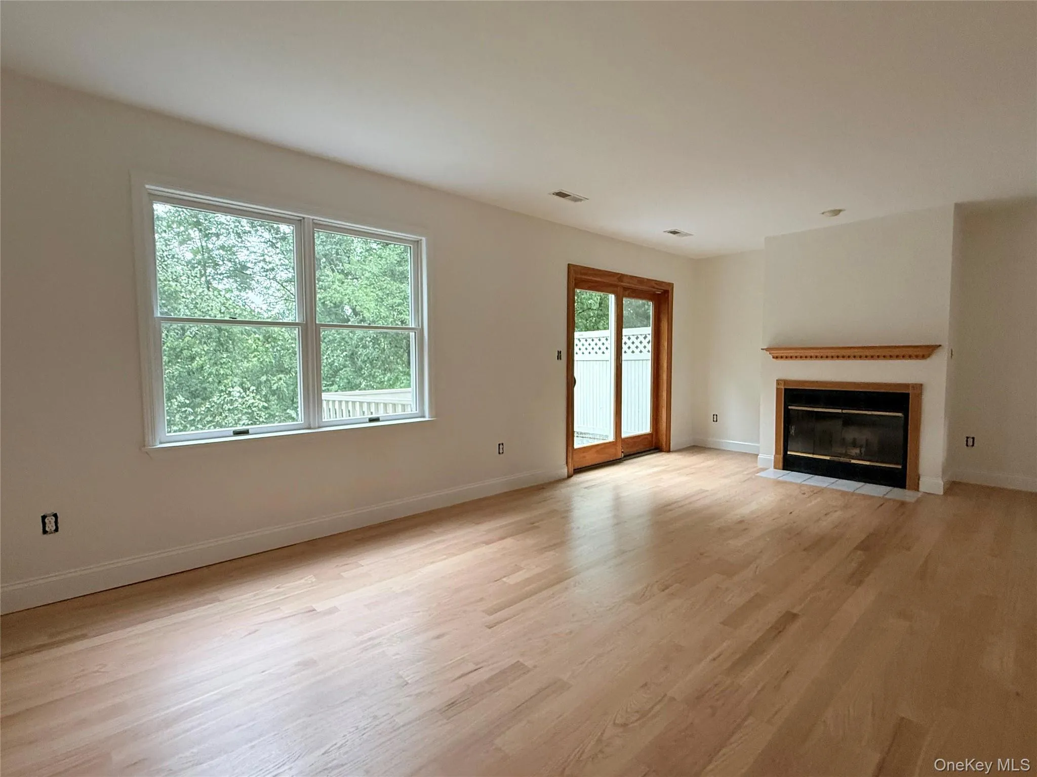 A bright and inviting living room designed for comfort and everyday living. The fireplace creates a warm focal point, while large windows bring in natural light A bright and inviting living room designed for comfort and everyday living. The fireplace creates a warm focal point, while large windows bring in natural light