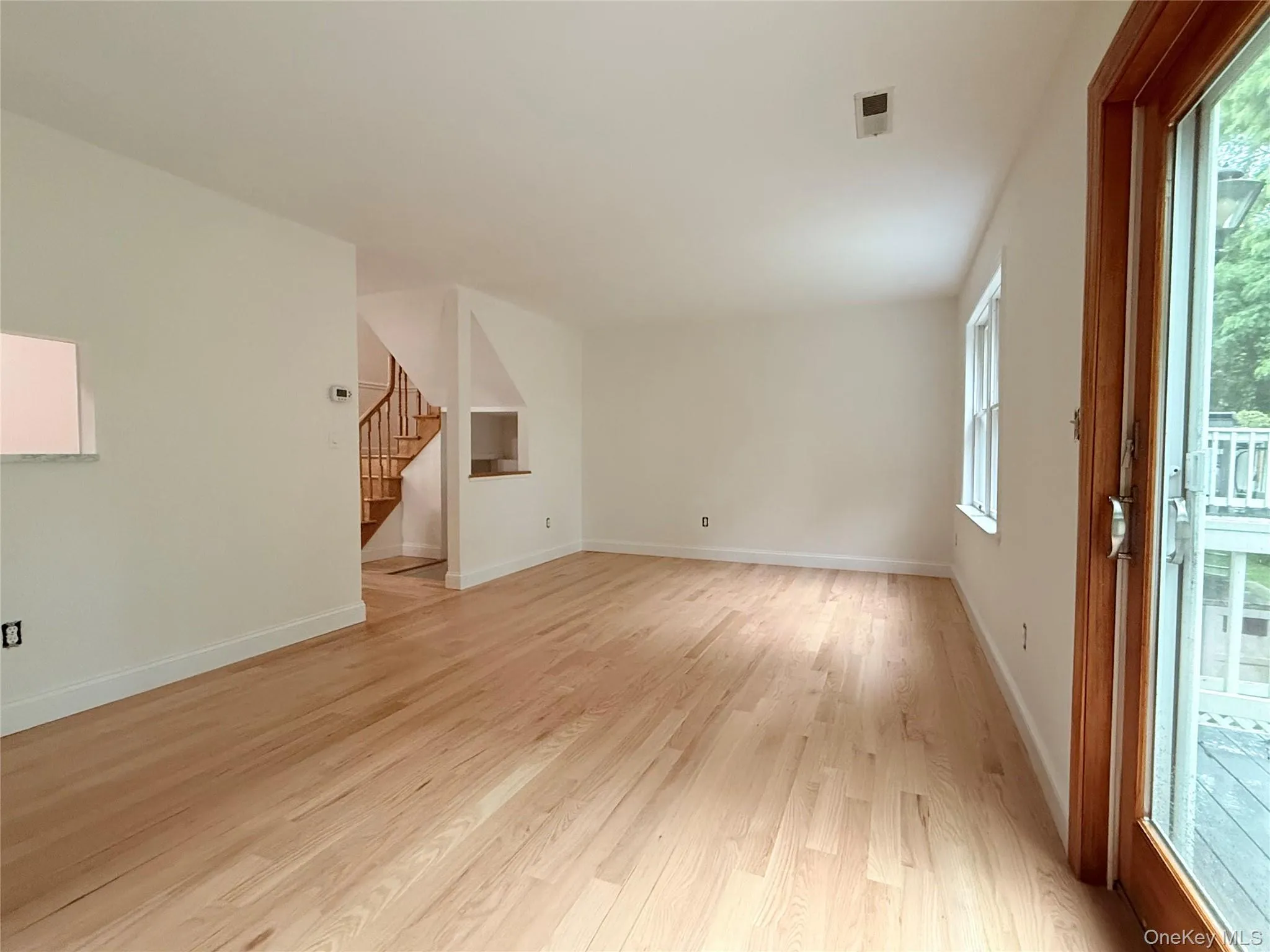 Another view of the spacious living room, featuring beautiful natural light and sliding glass doors that opens to the deck. Another view of the spacious living room, featuring beautiful natural light and sliding glass doors that opens to the deck.
