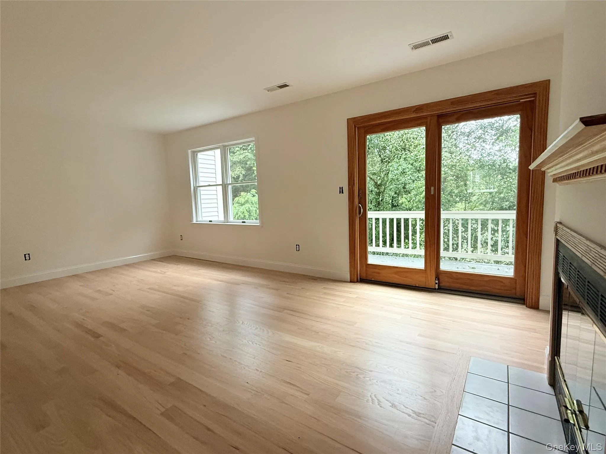 Living room with sliding glass doors leading to a private deck overlooking the wooded setting. Living room with sliding glass doors leading to a private deck overlooking the wooded setting.
