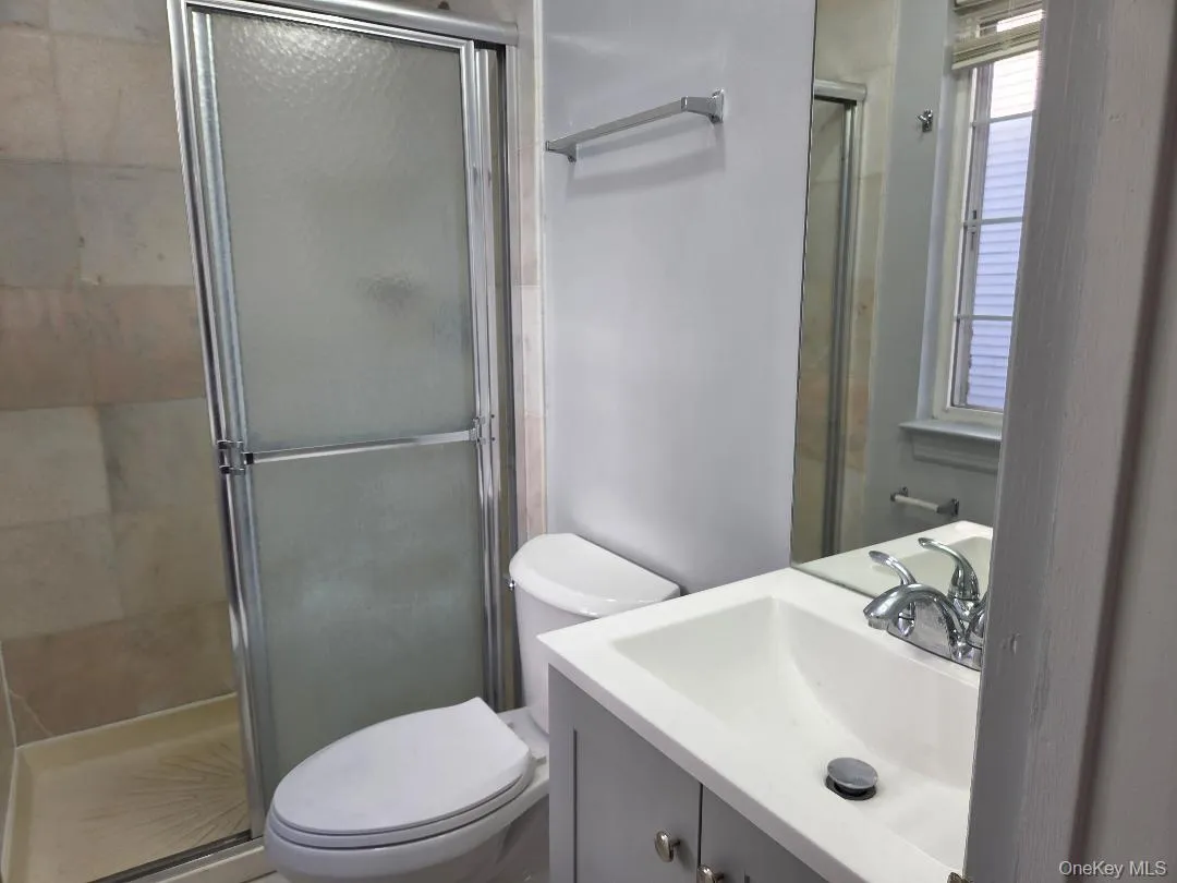 Full bath featuring tiled shower, vanity, and toilet Full bath featuring tiled shower, vanity, and toilet