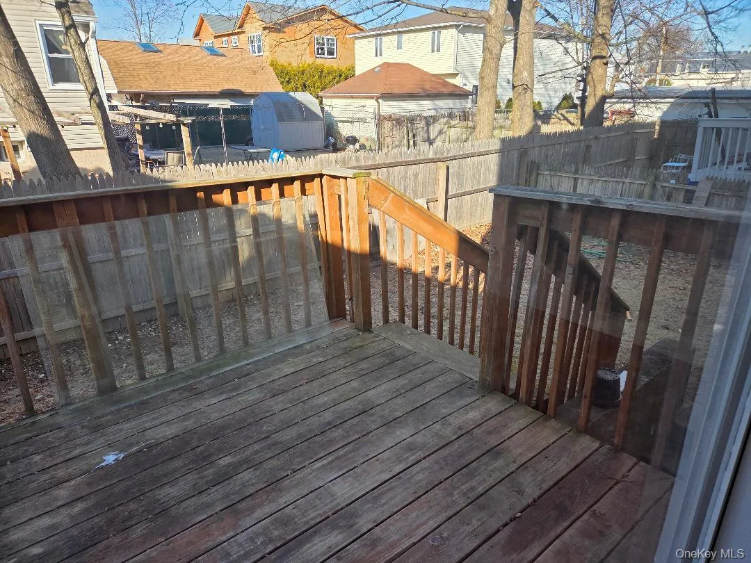 Wooden terrace featuring a fenced backyard, an outdoor structure, and a shed Wooden terrace featuring a fenced backyard, an outdoor structure, and a shed