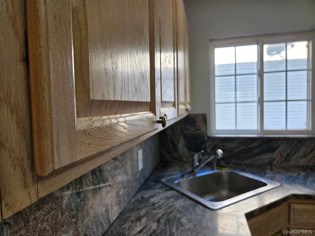 Kitchen featuring dark countertops and a sink Kitchen featuring dark countertops and a sink