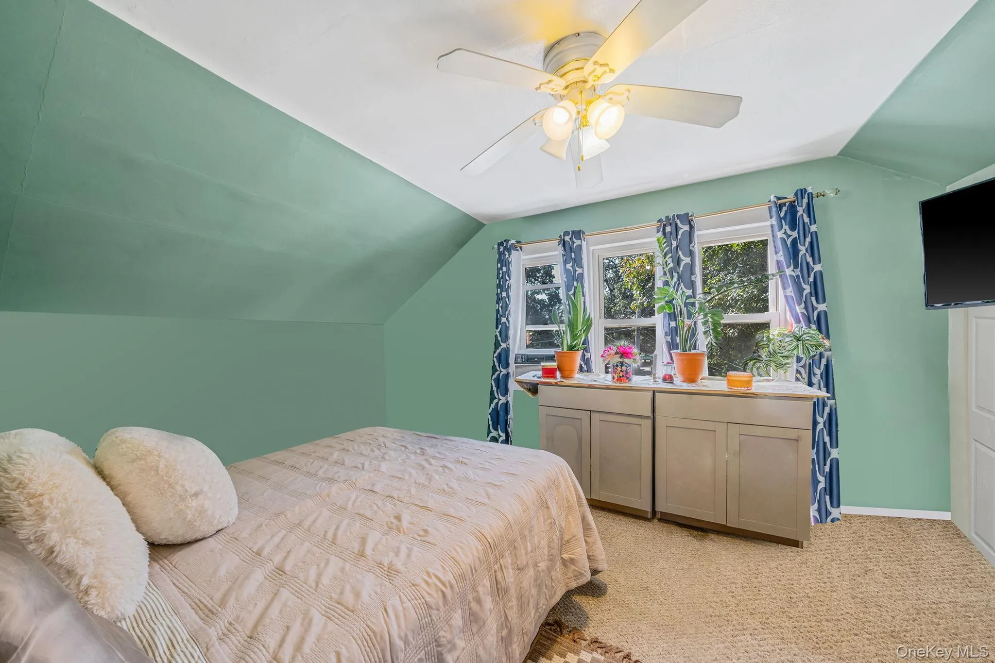 Bedroom featuring vaulted ceiling, light colored carpet, and ceiling fan Bedroom featuring vaulted ceiling, light colored carpet, and ceiling fan