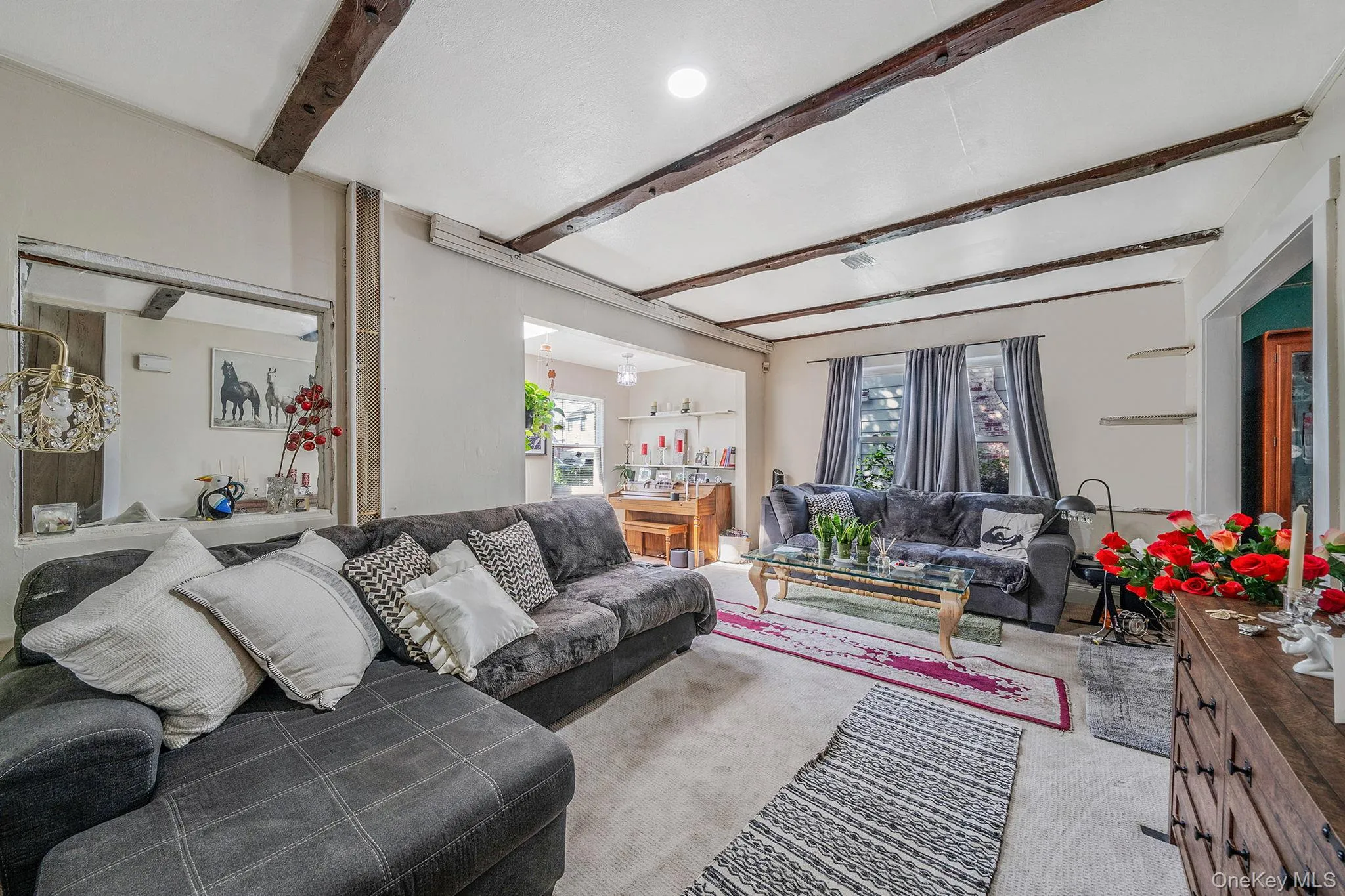 Carpeted living area with beam ceiling Carpeted living area with beam ceiling