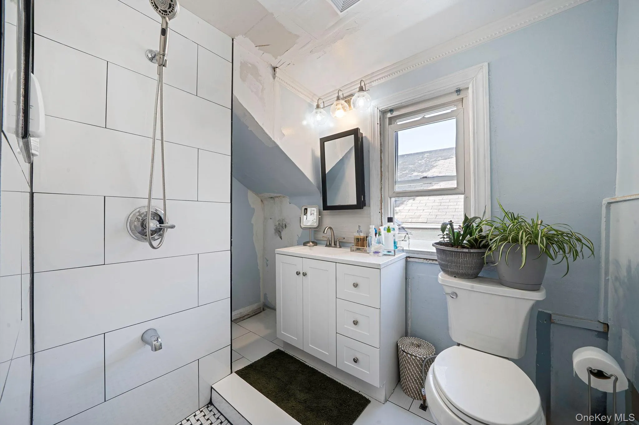 Bathroom with vanity, ornamental molding, and light tile patterned floors Bathroom with vanity, ornamental molding, and light tile patterned floors