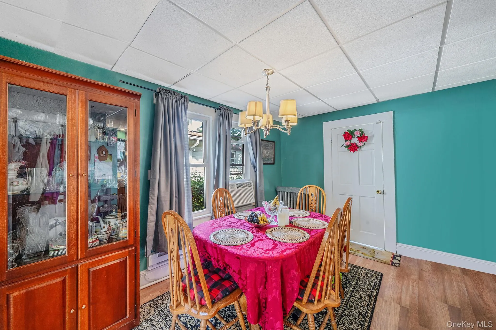 Dining room with a drop ceiling, wood finished floors, and a chandelier Dining room with a drop ceiling, wood finished floors, and a chandelier