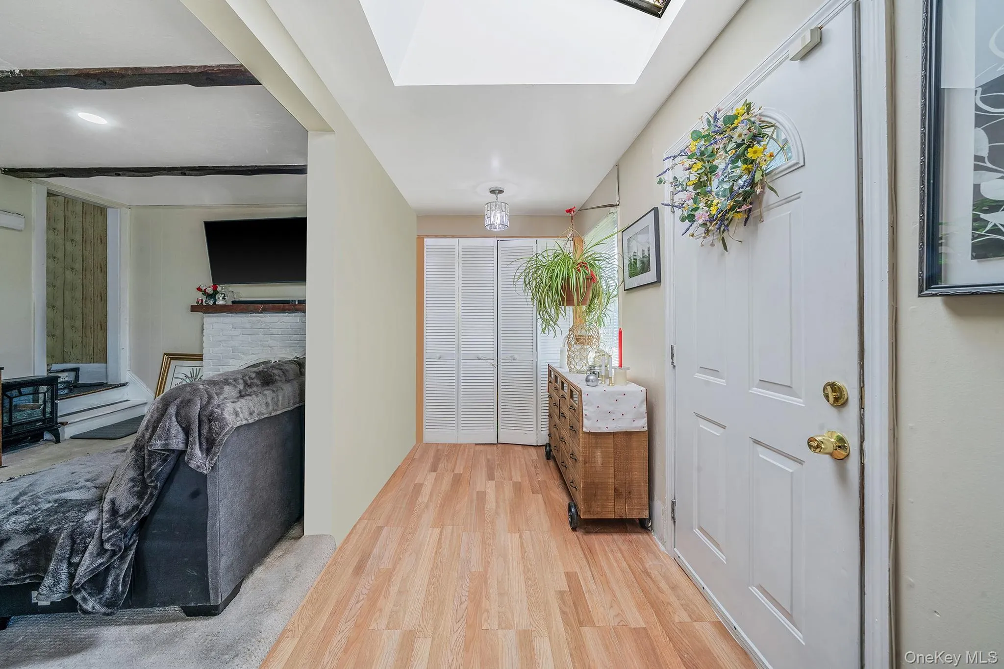 Entryway with light wood-style floors and a skylight Entryway with light wood-style floors and a skylight