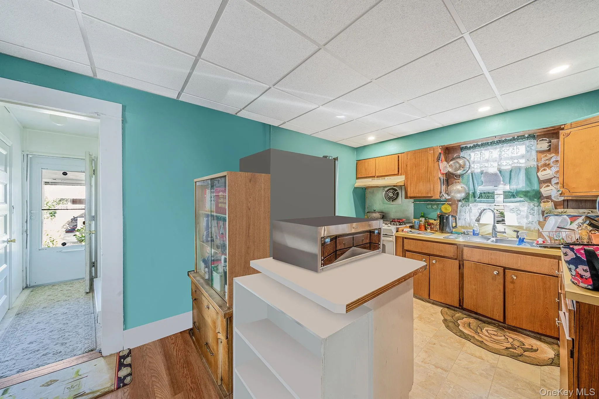 Kitchen with light countertops, brown cabinetry, a paneled ceiling, gas range gas stove, and light wood-style floors Kitchen with light countertops, brown cabinetry, a paneled ceiling, gas range gas stove, and light wood-style floors