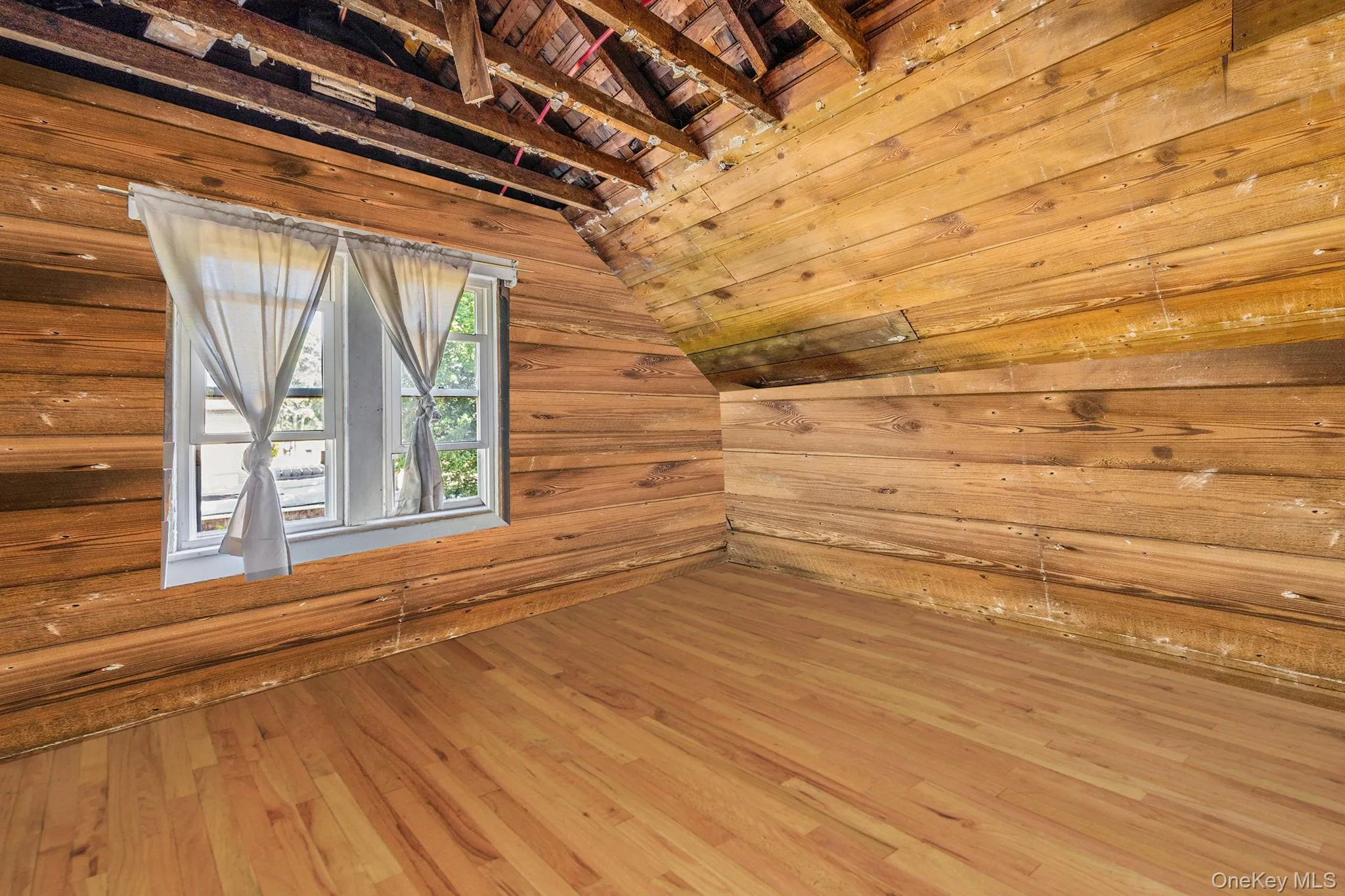 Additional living space featuring vaulted ceiling, wood-type flooring, wood ceiling, and wooden walls Additional living space featuring vaulted ceiling, wood-type flooring, wood ceiling, and wooden walls