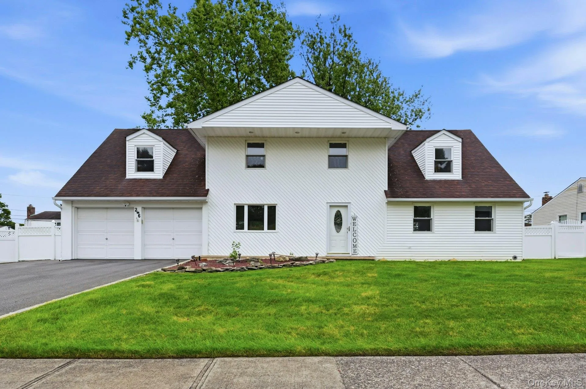 Two-story residence featuring white vinyl siding and a dark shingle roof Two-story residence featuring white vinyl siding and a dark shingle roof