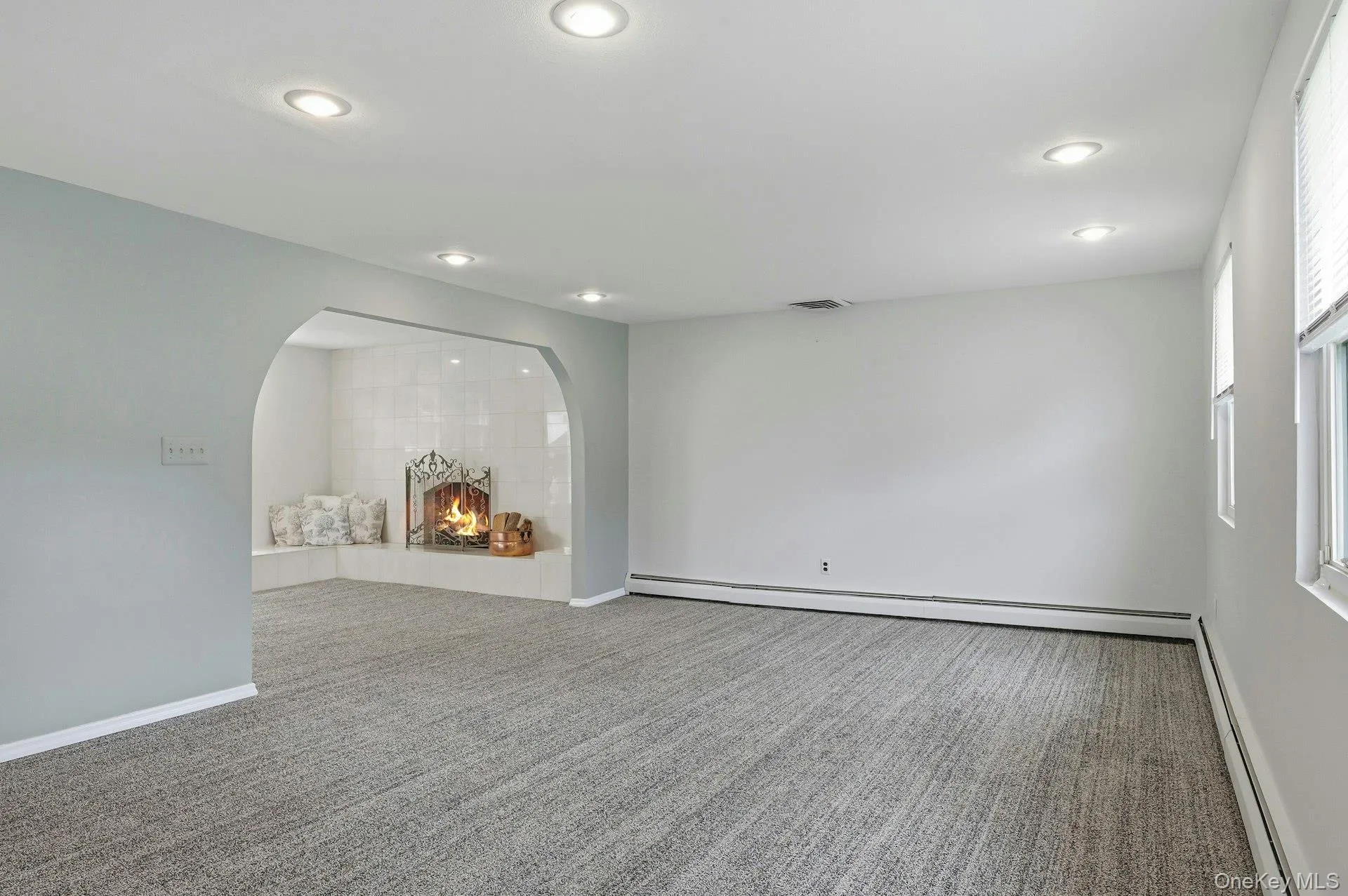 Spacious room featuring neutral carpeting, recessed lighting, and white baseboard trim Spacious room featuring neutral carpeting, recessed lighting, and white baseboard trim