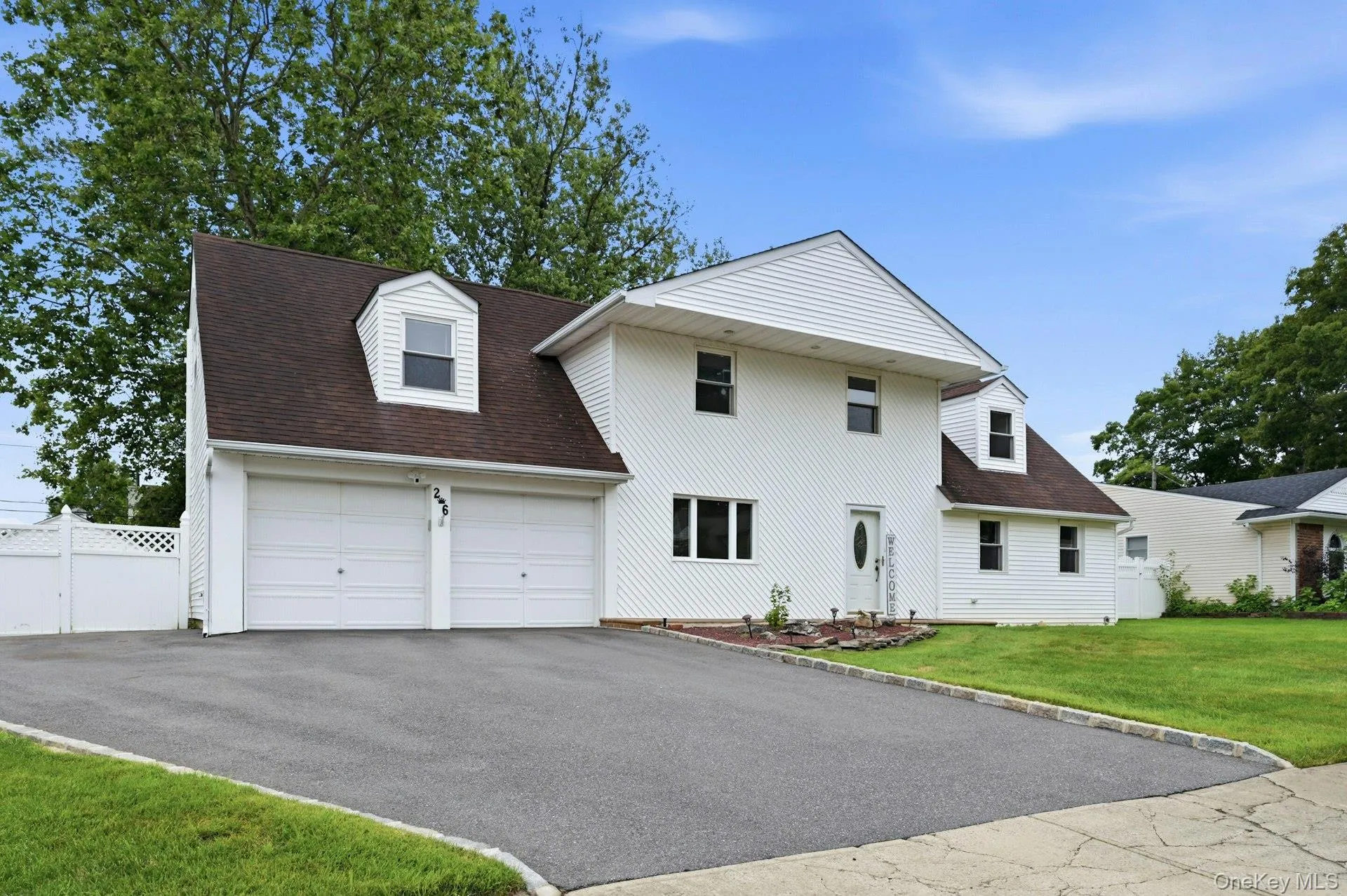 White siding exterior with a dark shingle roof and multiple dormer windows White siding exterior with a dark shingle roof and multiple dormer windows
