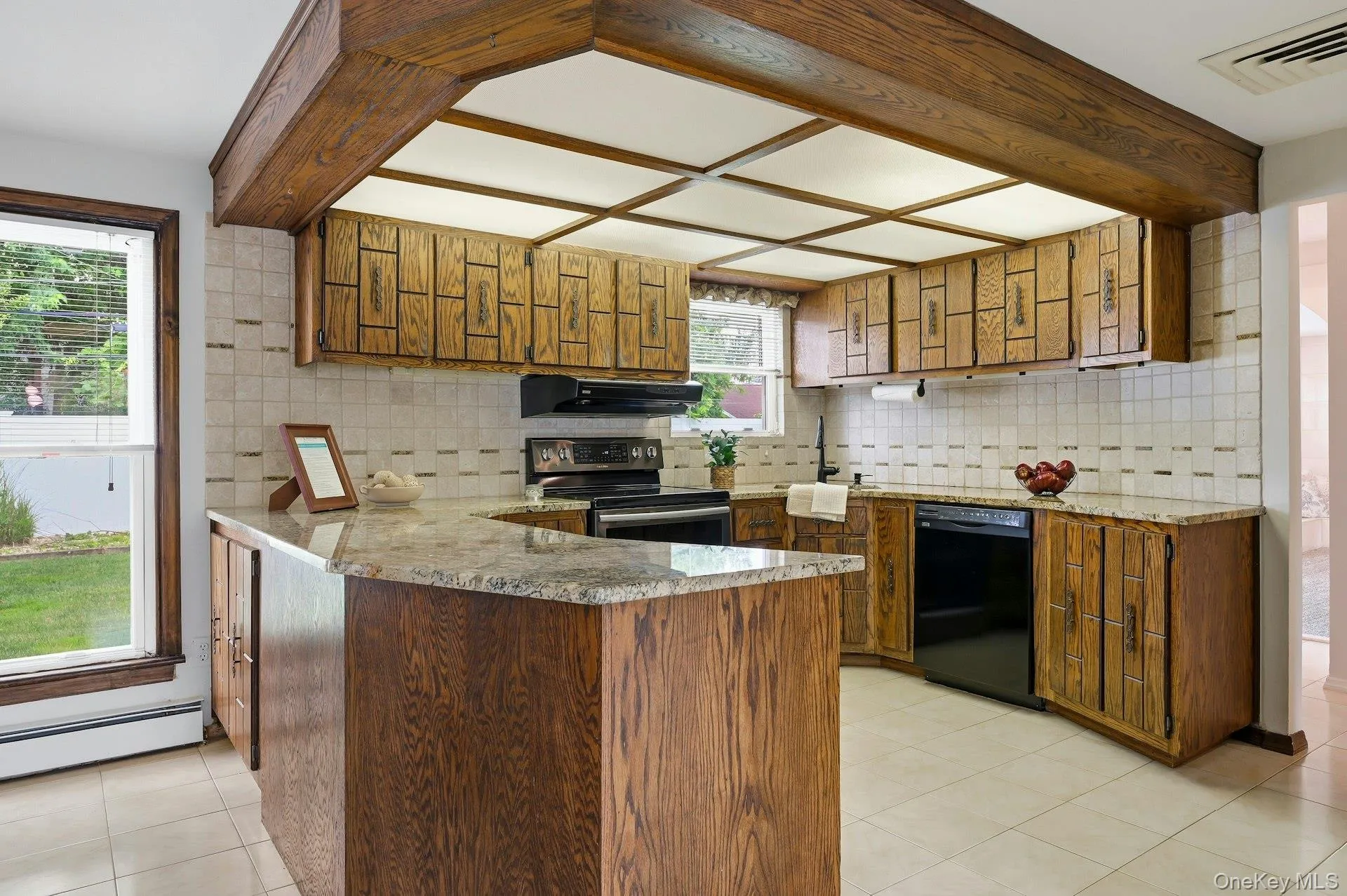 Kitchen featuring wood-finish cabinetry, light-toned tiled backsplash, and granite-style countertops Kitchen featuring wood-finish cabinetry, light-toned tiled backsplash, and granite-style countertops
