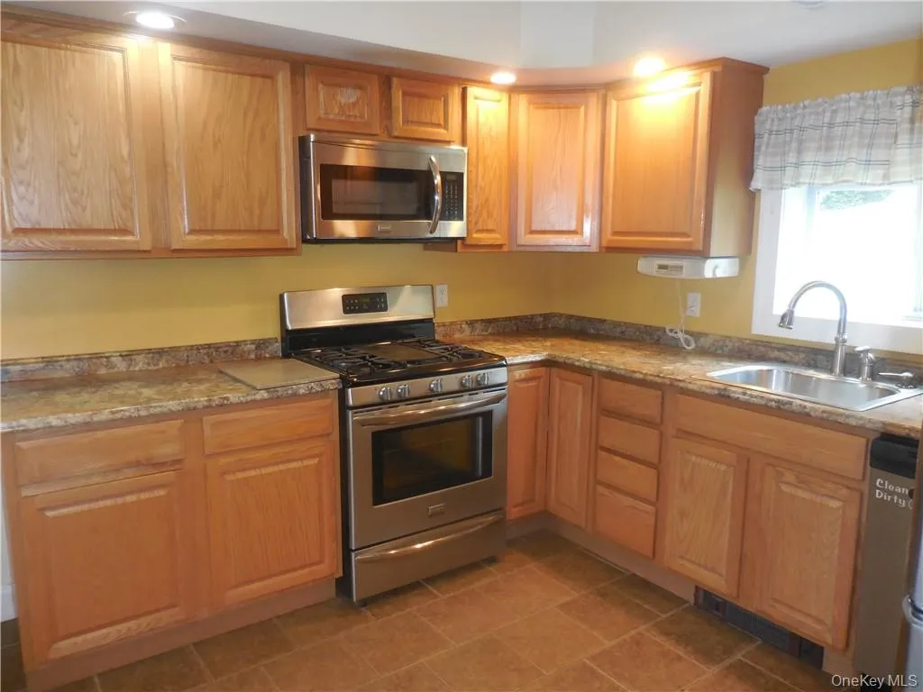 Kitchen with sink, stainless steel appliances, and tile patterned floors Kitchen with sink, stainless steel appliances, and tile patterned floors
