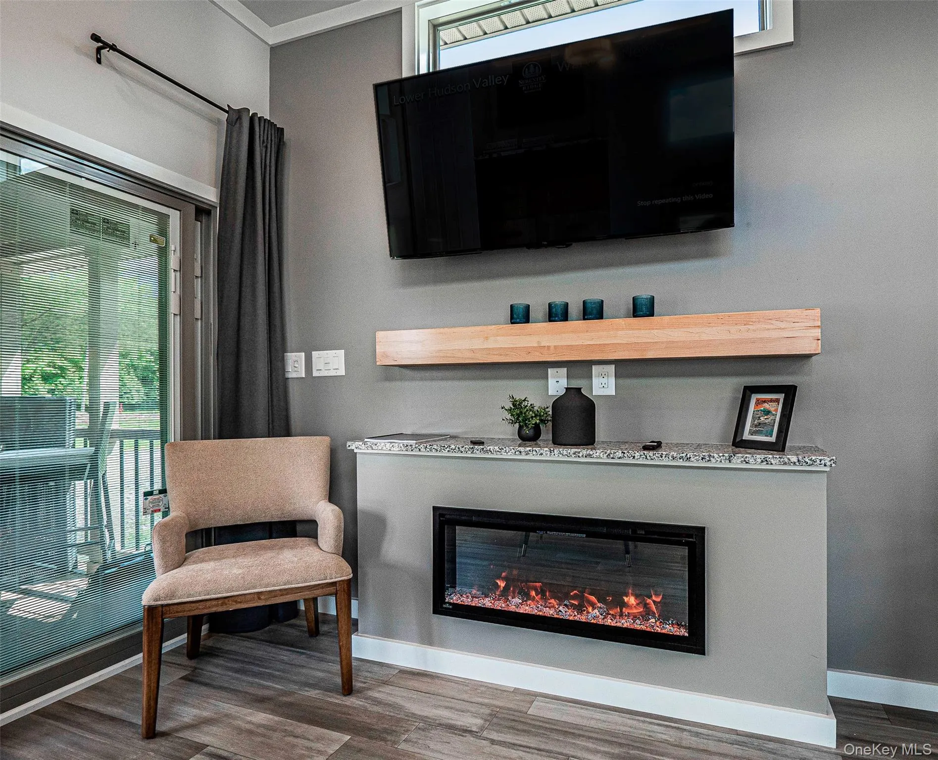 Living room with a glass covered electric fireplace and LVP finished floors Living room with a glass covered electric fireplace and LVP finished floors