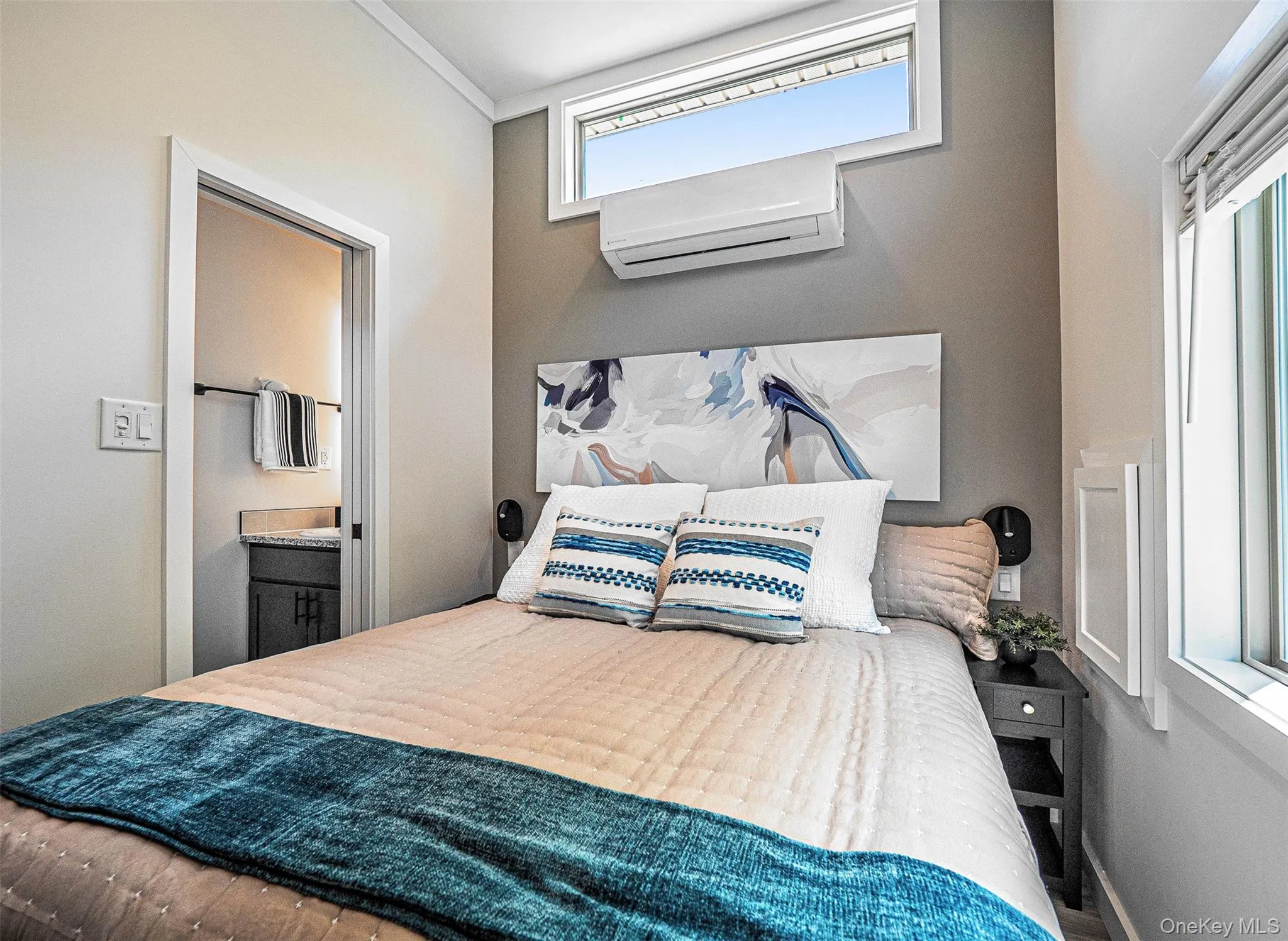 Primary bedroom with a wall unit AC and ensuite bath Primary bedroom with a wall unit AC and ensuite bath
